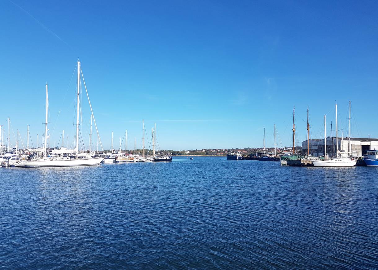 Aussicht auf den Jachthafen, links große Segeljachten, rechts eine Werft