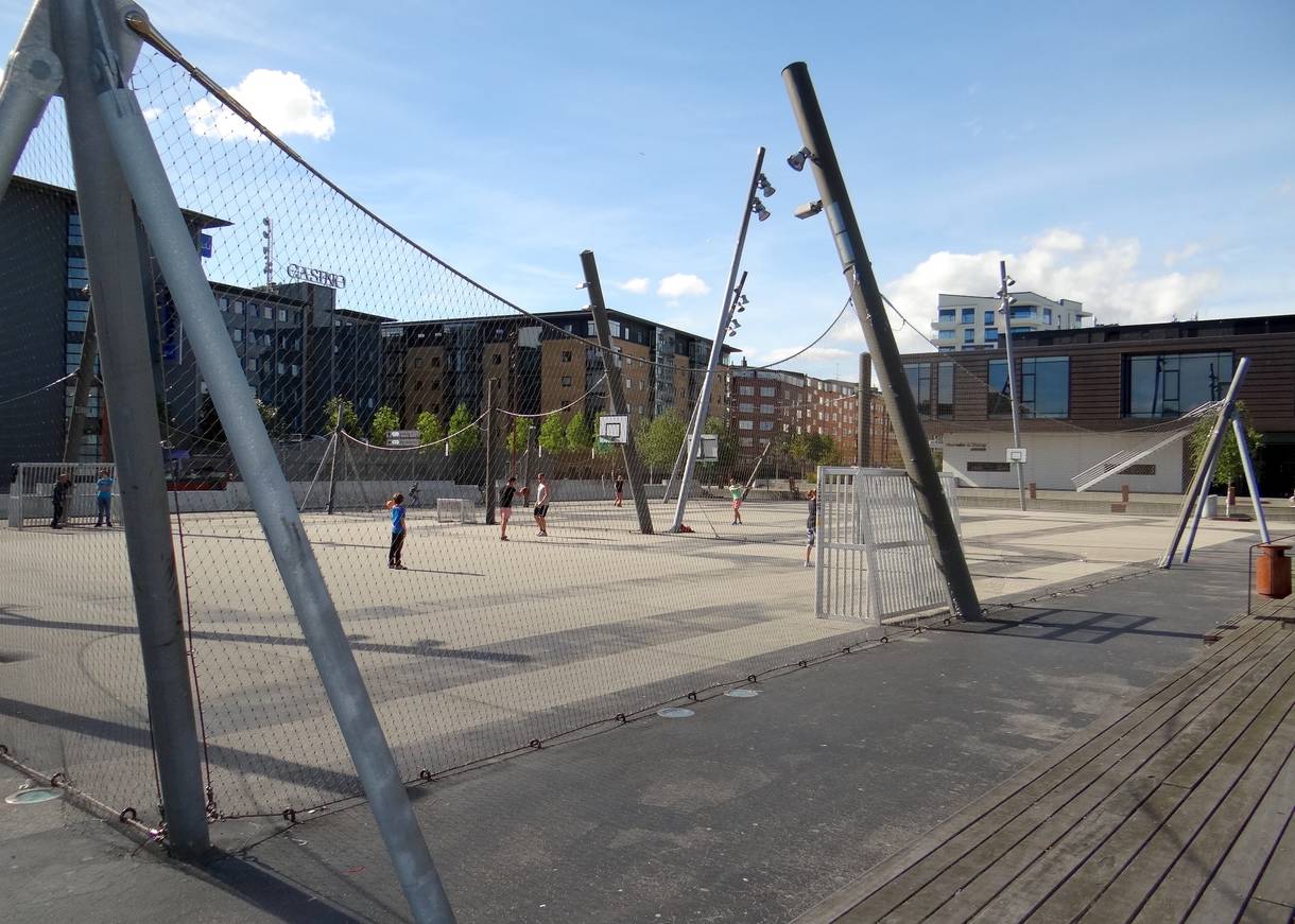 Ballspielplätze an der Hafenfront mit Toren, Beleuchtung und ein paar Sportlern