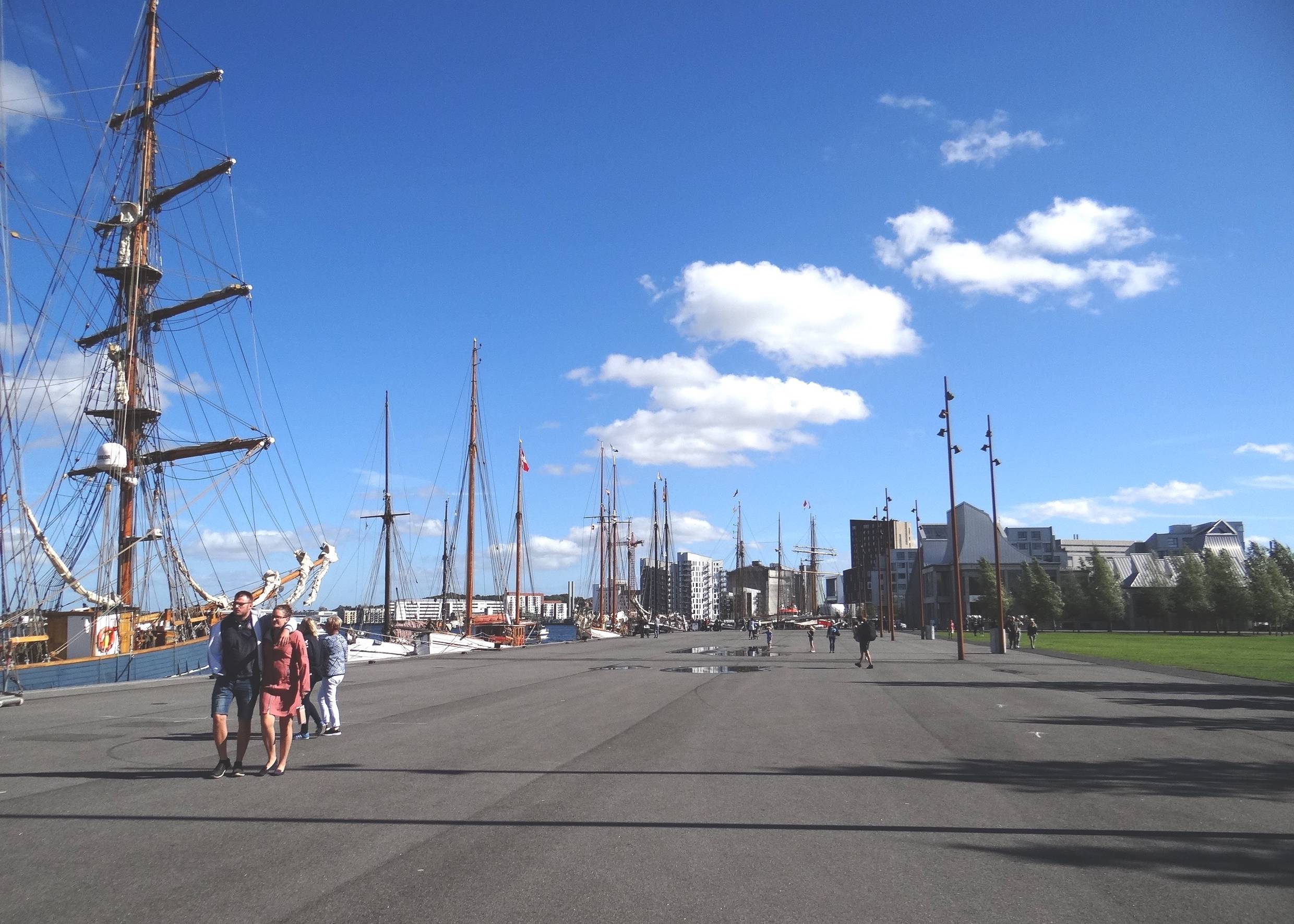 Hafenprmenade mit Segelschiffen und Fußgängern