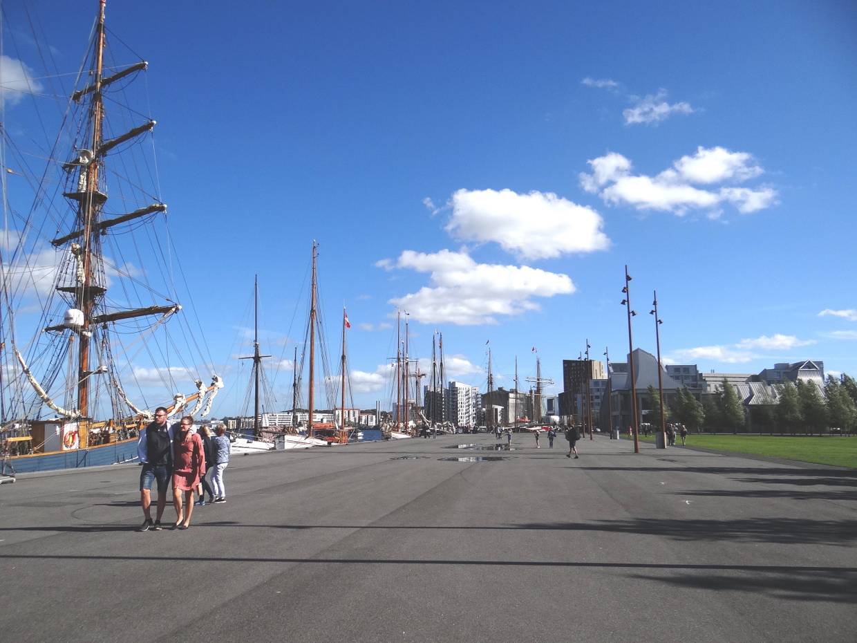 Hafenprmenade mit Segelschiffen und Fußgängern