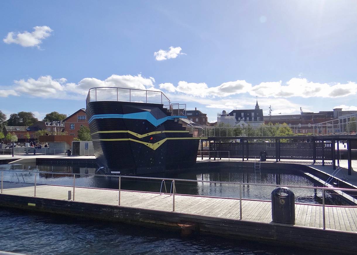 Hölzerner Badesteg mit einem Aufbau, der an ein Schiff erinnert