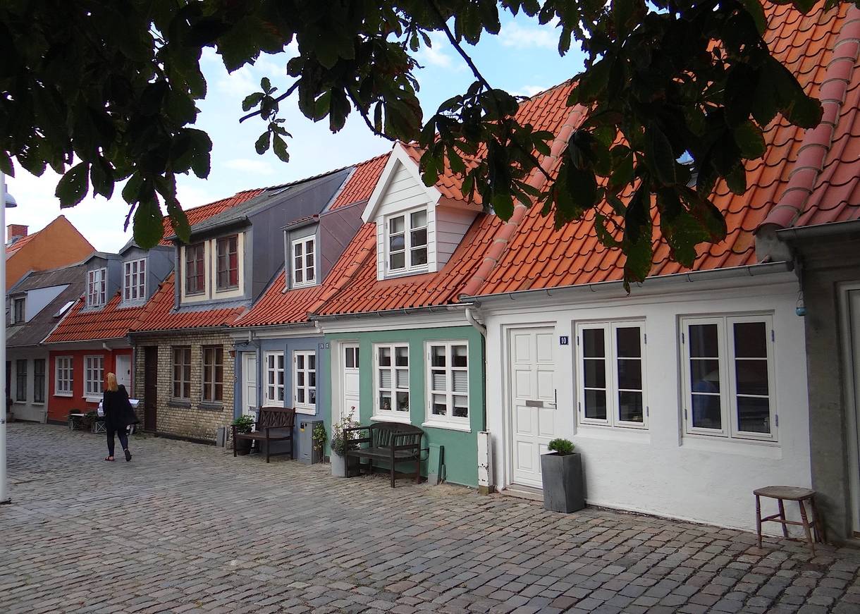 Kopfsteinpflastergasse mit farbigen, kleinen Wohnhäusern