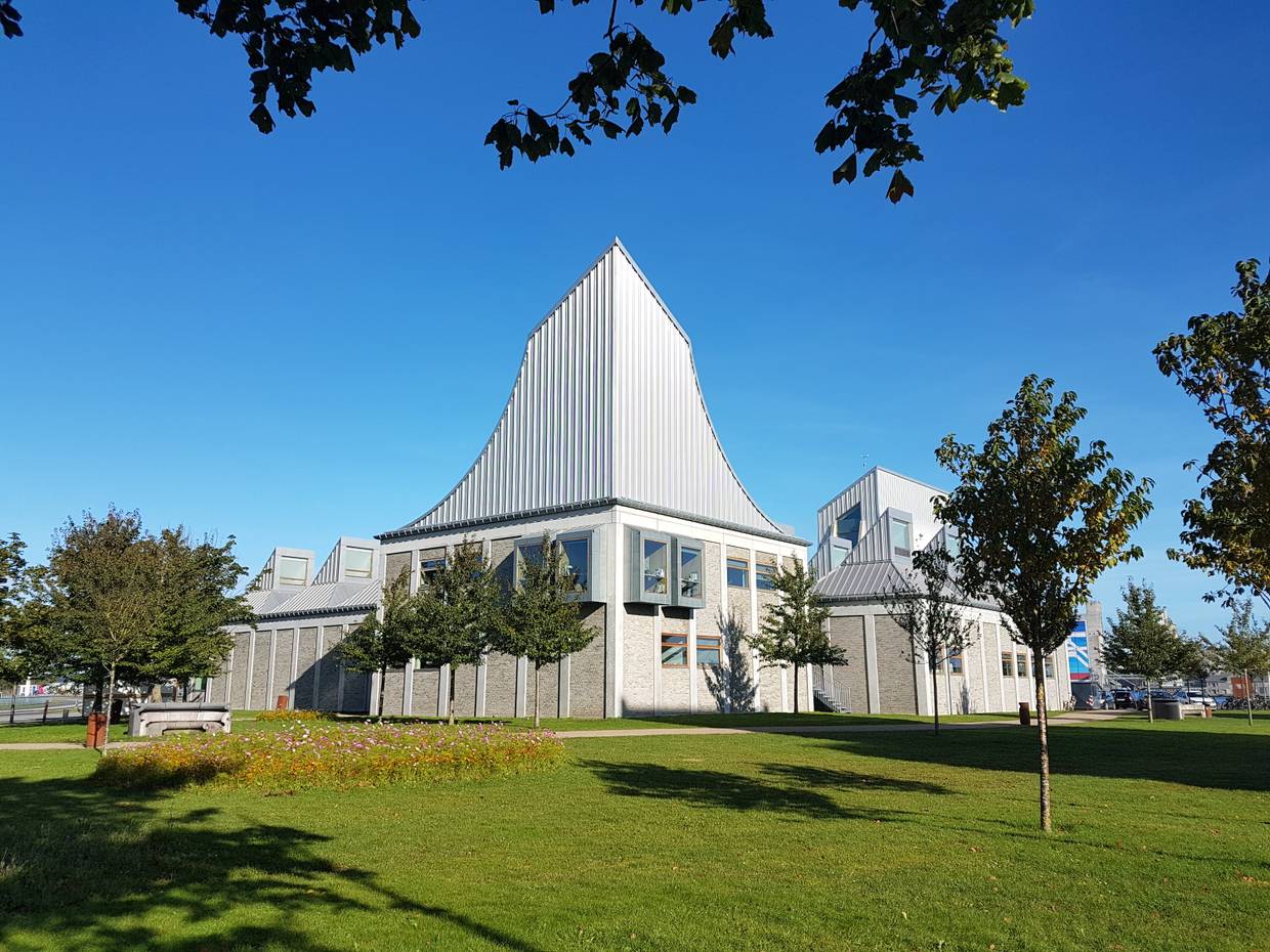 Modernes Gebäude mit ungewöhnlich nach oben aufragenden Dachfirst