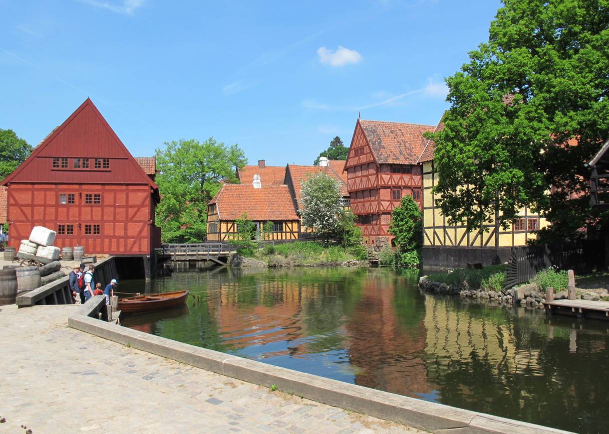 Rote und gelbe Fachwerkhäuser um einen künstlichen See