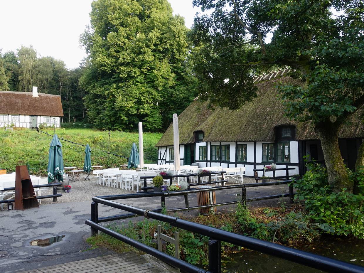 Fachwerkhaus mit einem Restaurant, davor weiße Gartenmöbel
