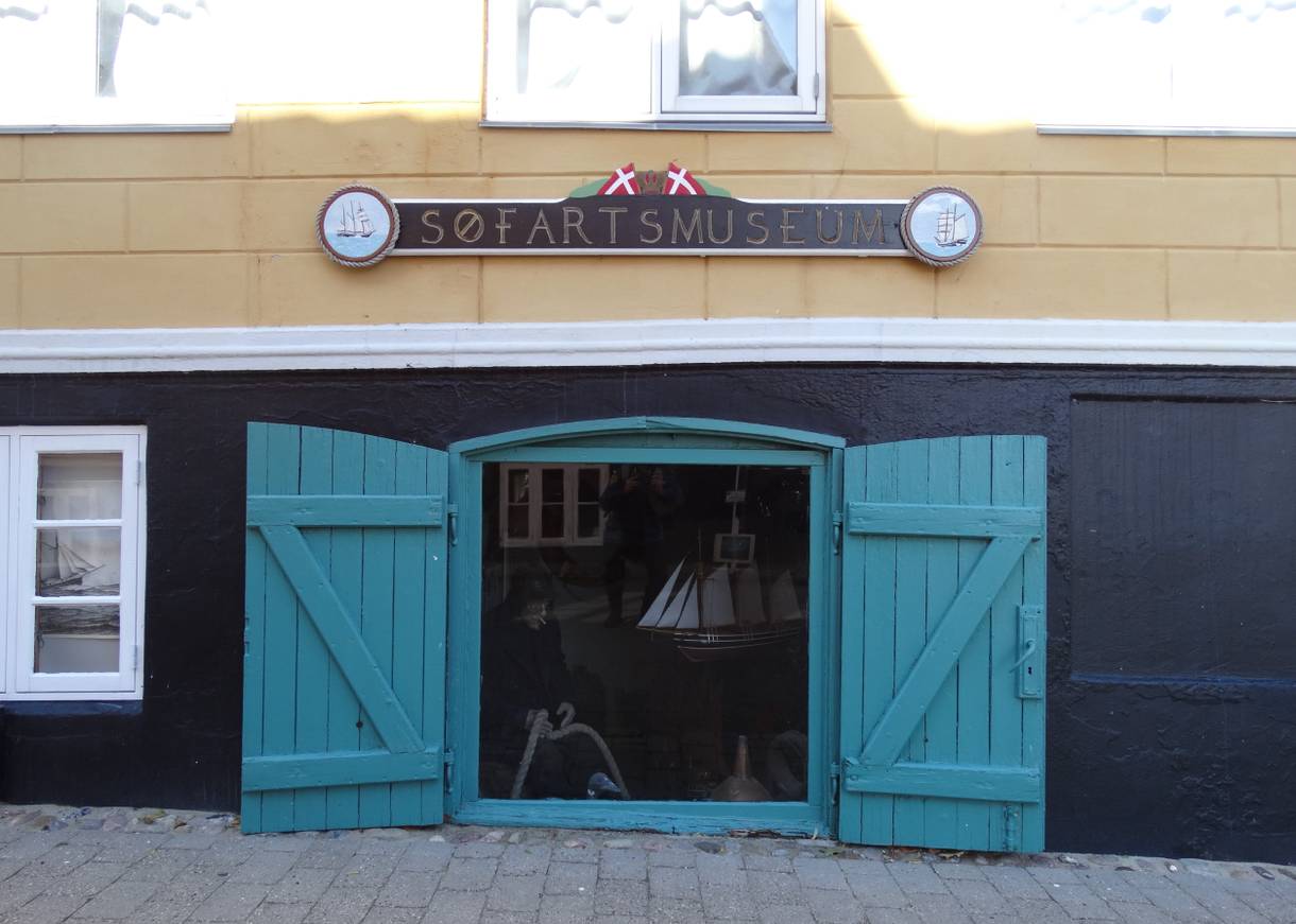 Gelb-schwarze Haus mit einer geföffneten blauen Kellerluke