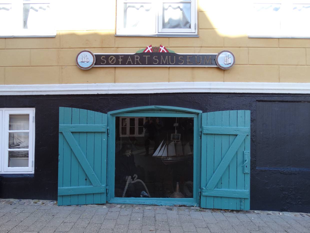 Gelb-schwarze Haus mit einer geföffneten blauen Kellerluke