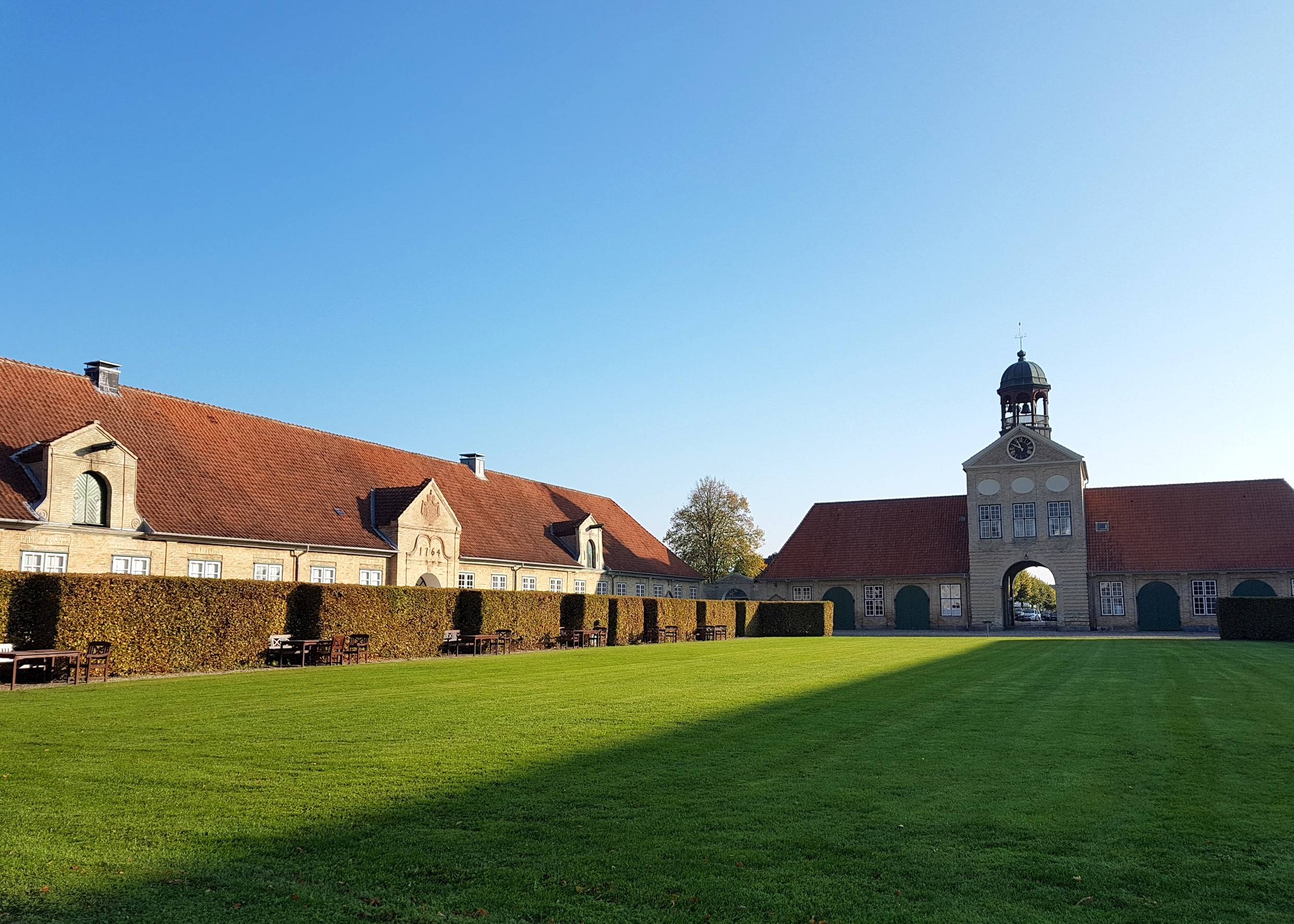 Rasenfläche zwischern einem Tothaus und Nebengebäuden
