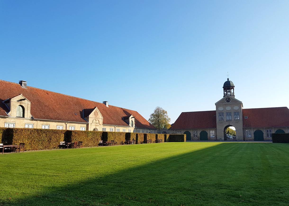 Rasenfläche zwischern einem Tothaus und Nebengebäuden