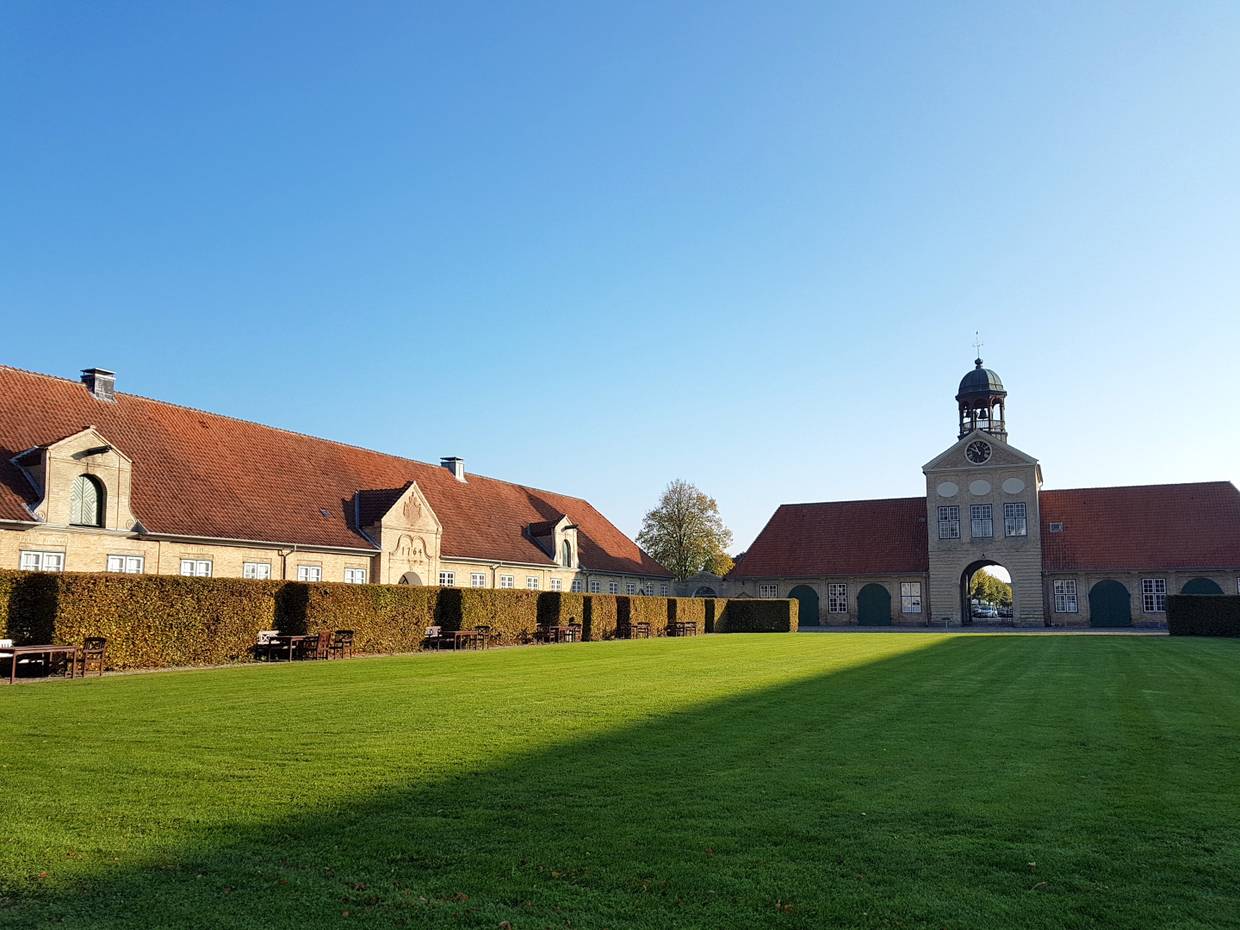 Rasenfläche zwischern einem Tothaus und Nebengebäuden