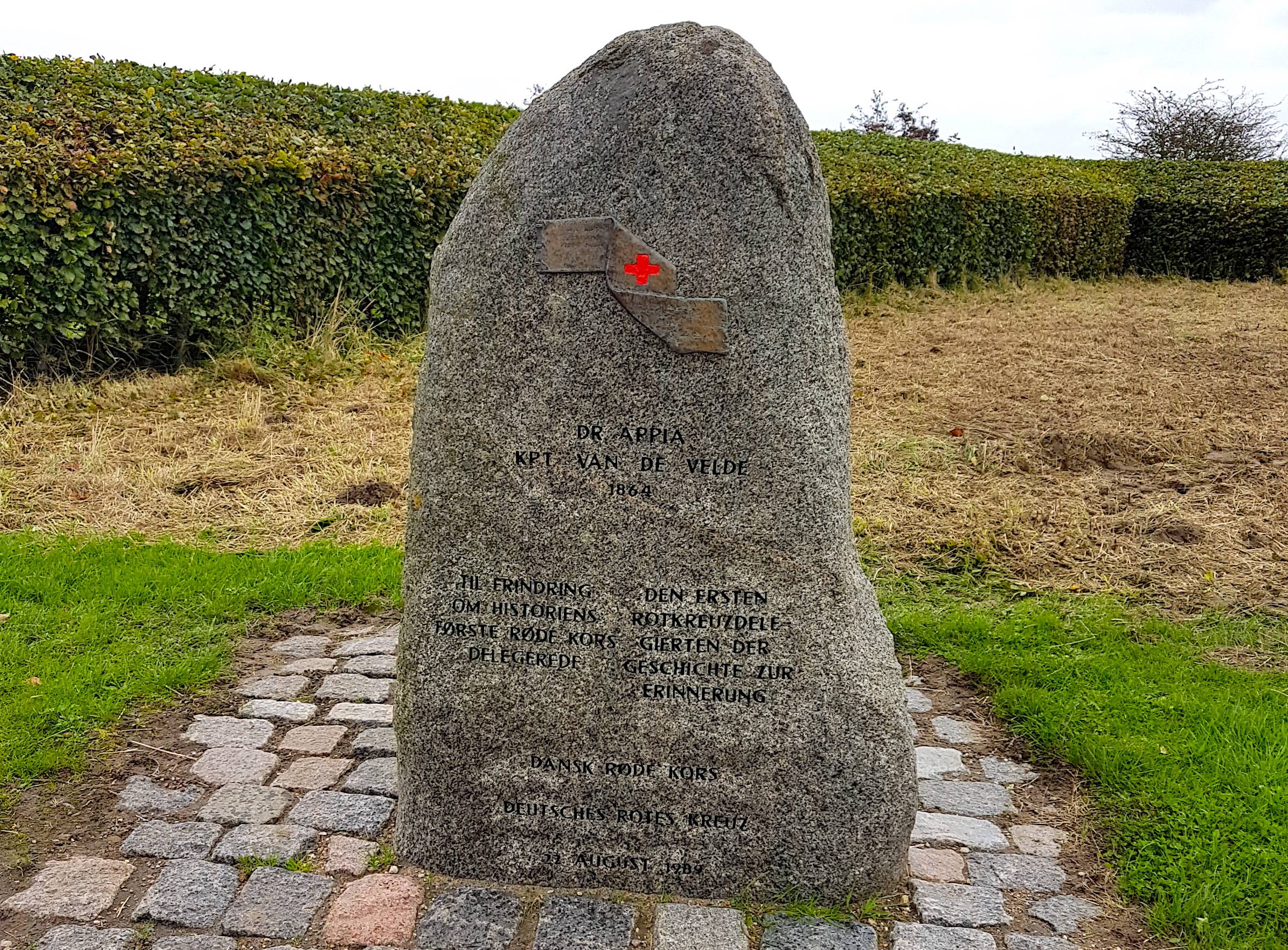 Granitstein mit einem Rote-Kreuz-Symbol über der Inschrift