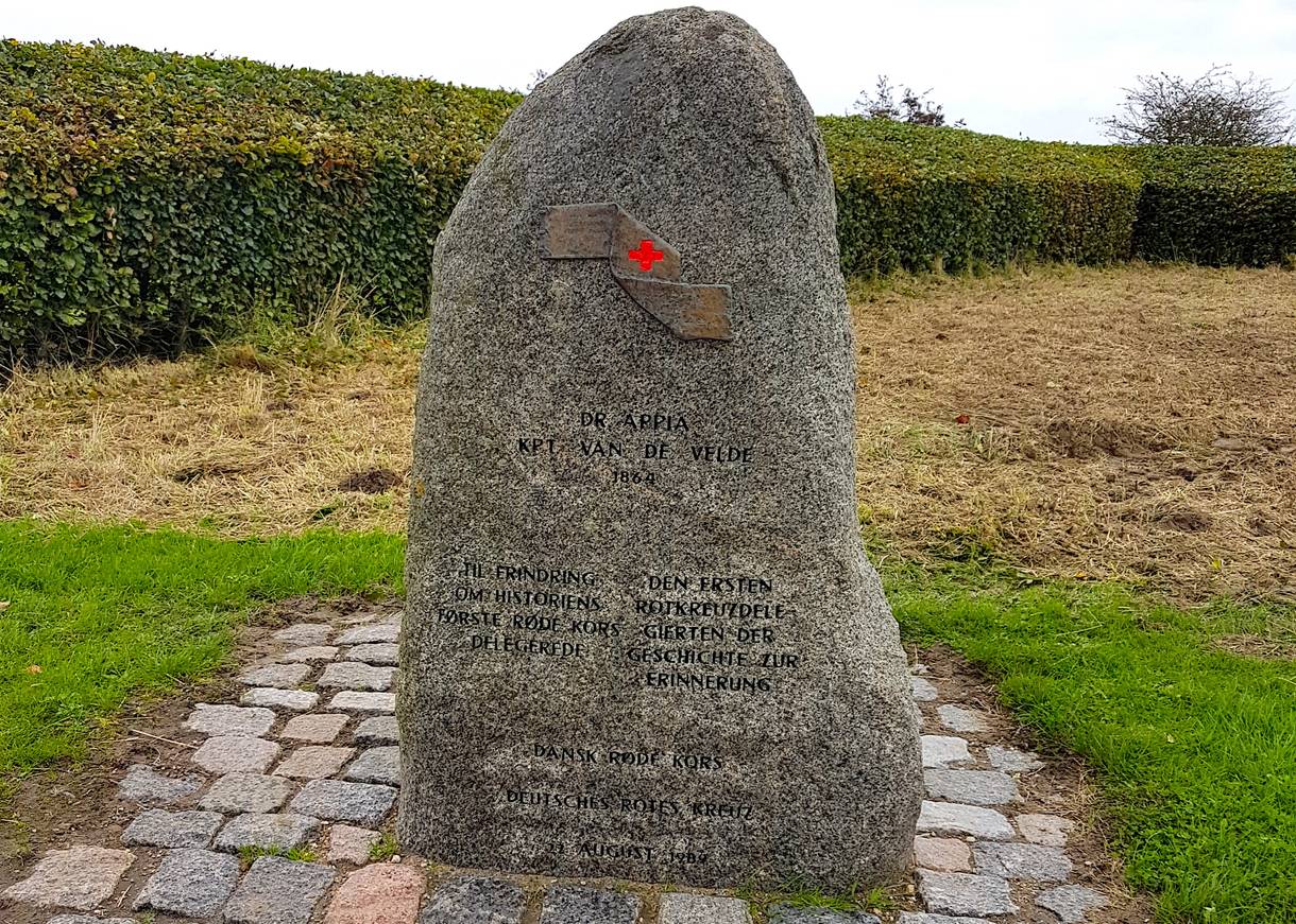 Granitstein mit einem Rote-Kreuz-Symbol über der Inschrift