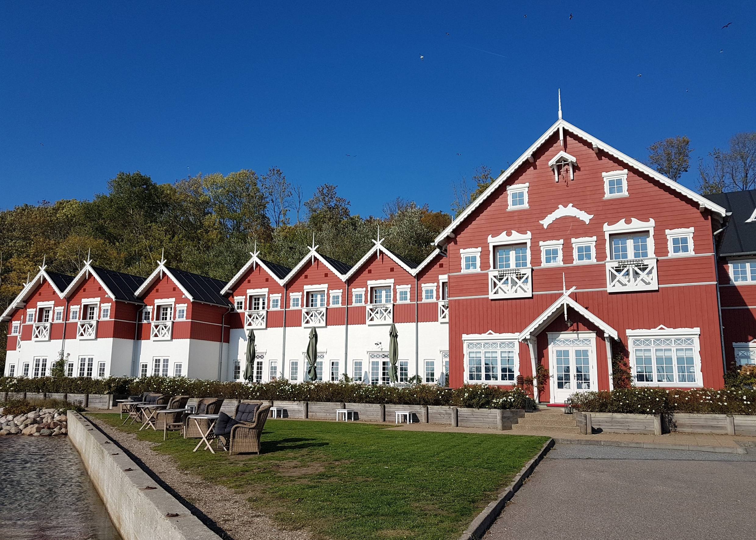 Großes rotes Holzgebäude mit blühende Büsche davor