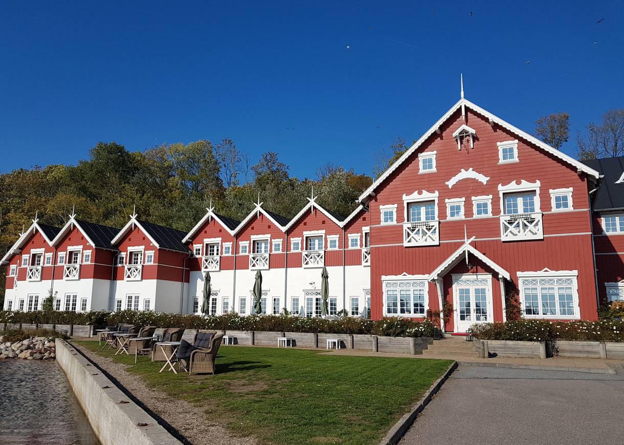 Großes rotes Holzgebäude mit blühende Büsche davor