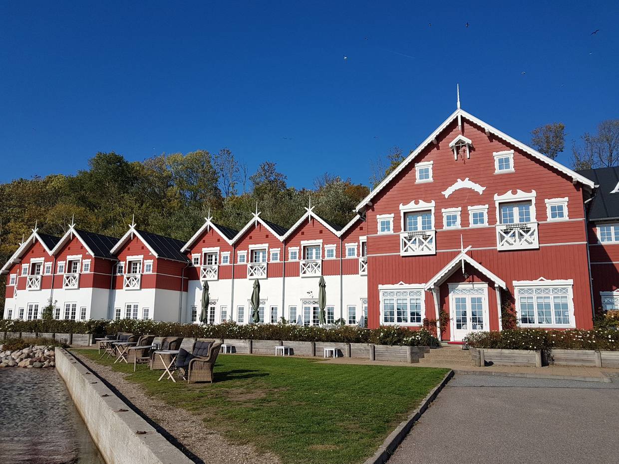 Großes rotes Holzgebäude mit blühende Büsche davor