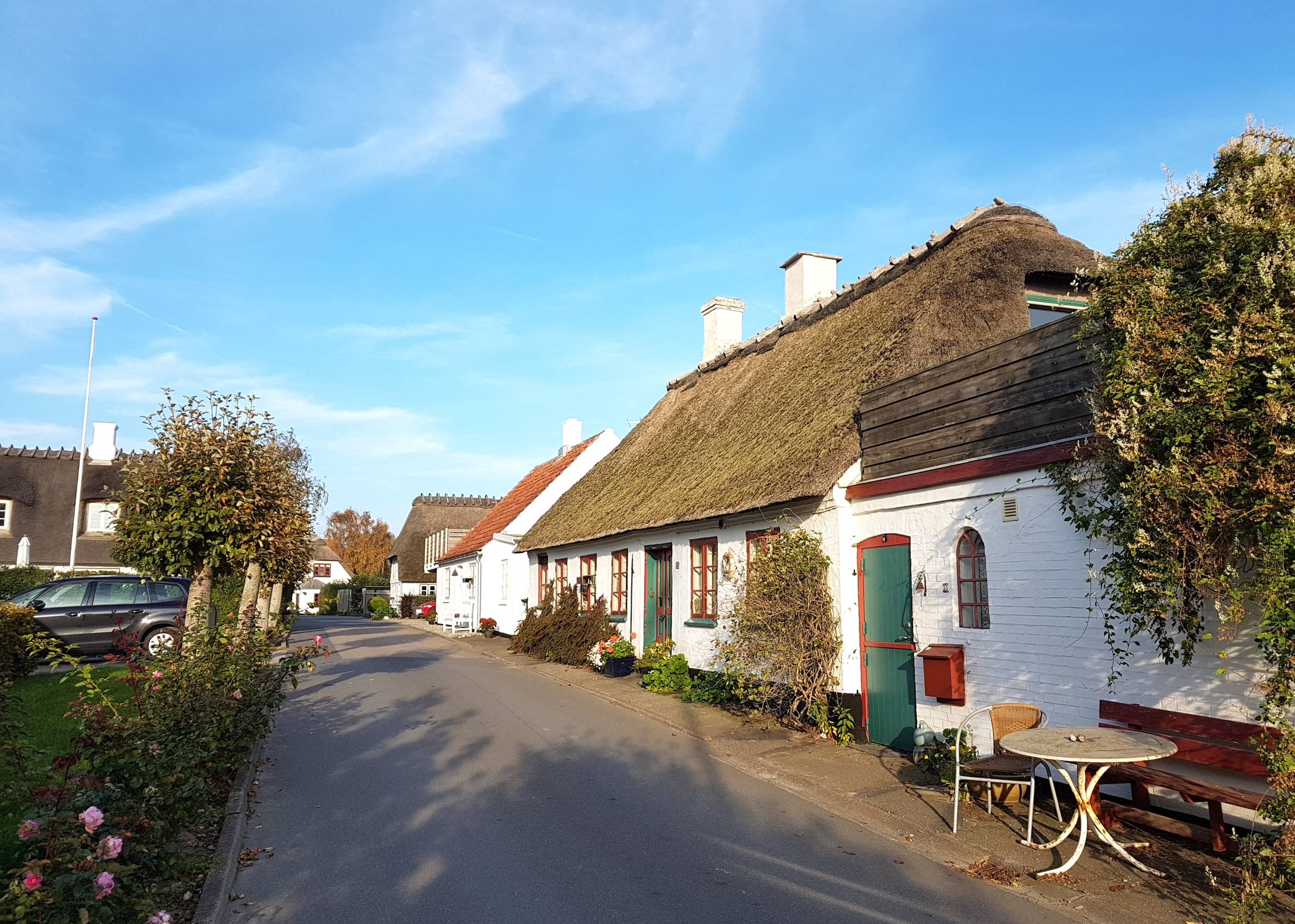 Blick auf eine schmale Straße mit weißen Reetdachäusern