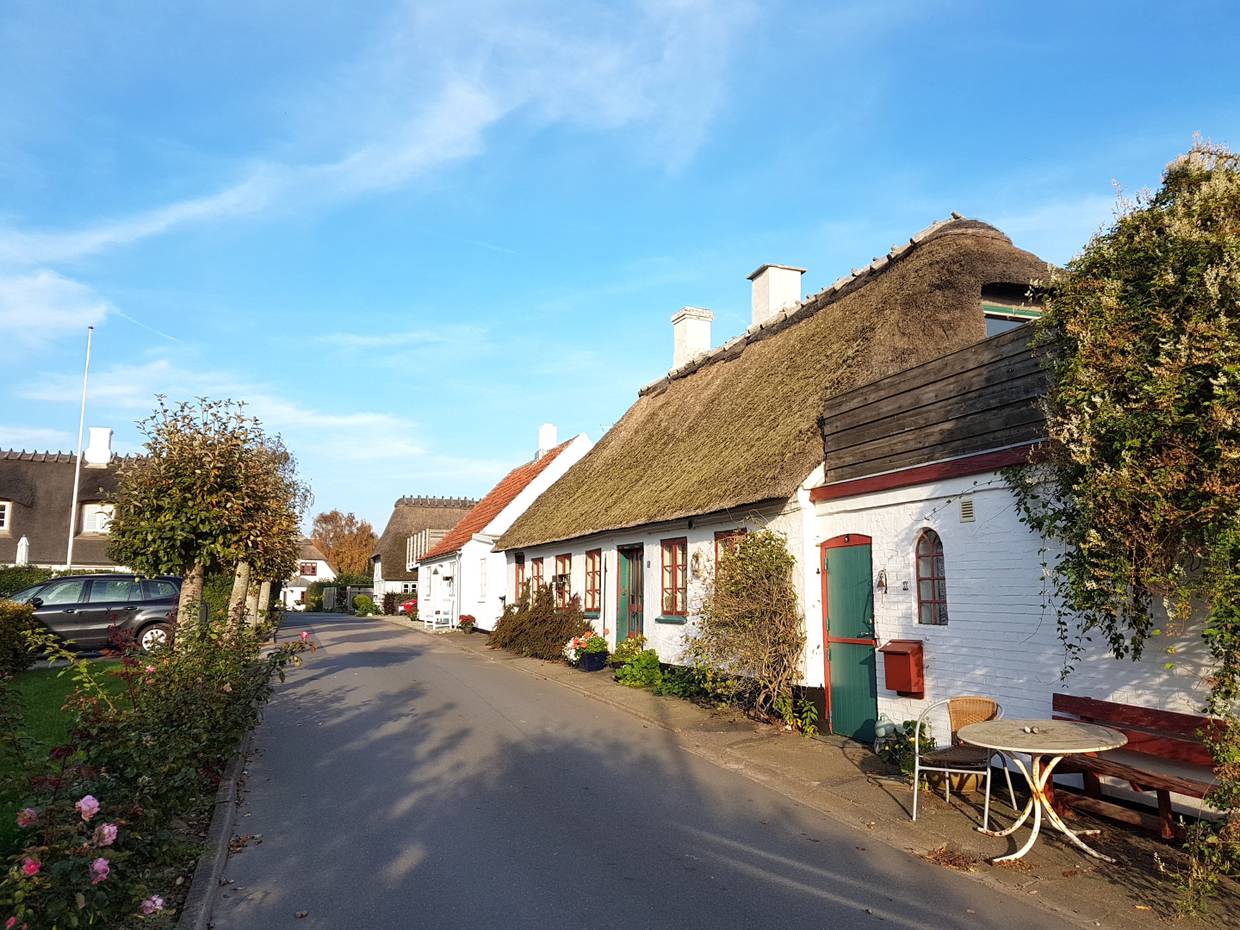 Blick auf eine schmale Straße mit weißen Reetdachäusern