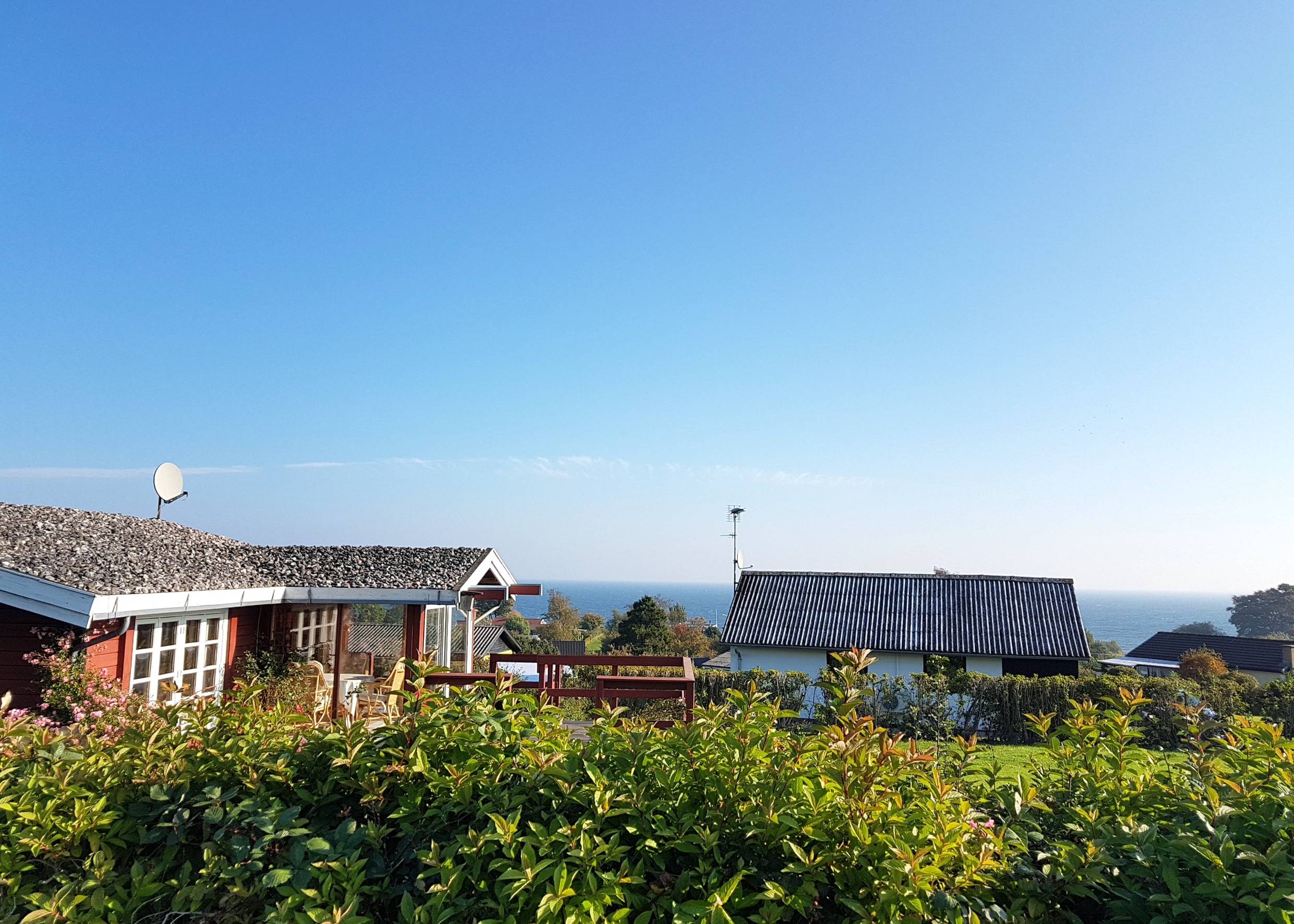 Blick über Ferienhausdächer zum Meer