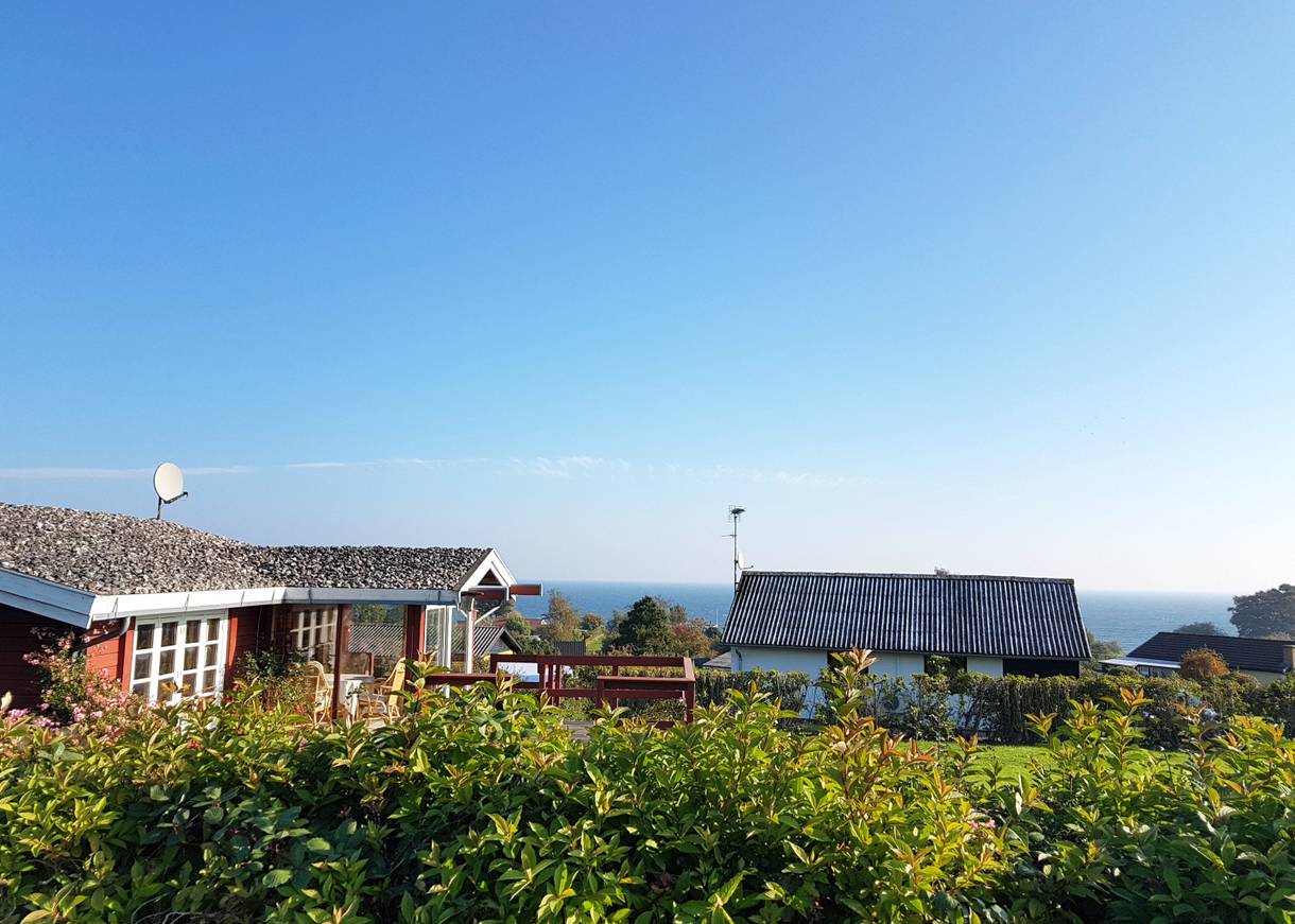 Blick über Ferienhausdächer zum Meer