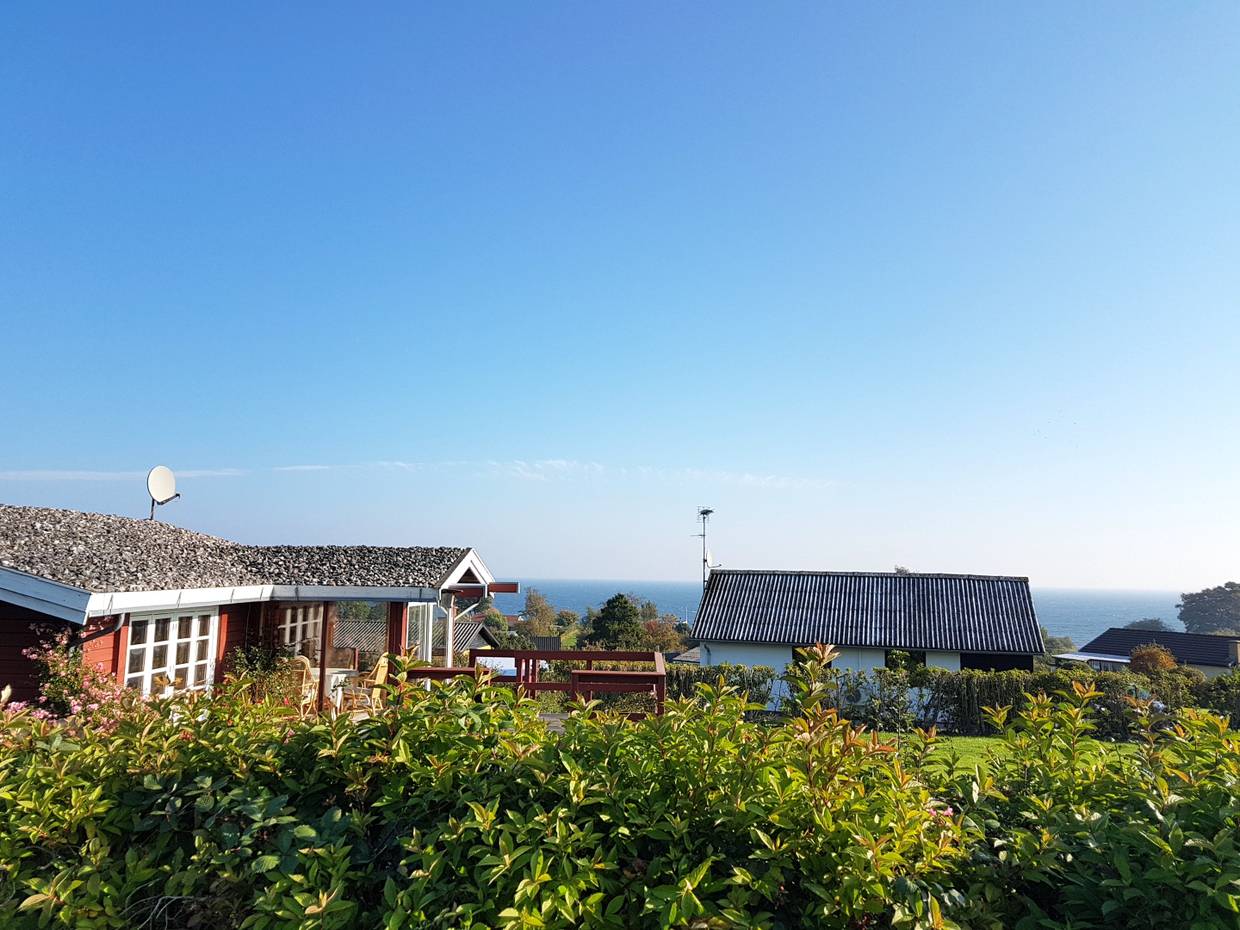 Blick über Ferienhausdächer zum Meer