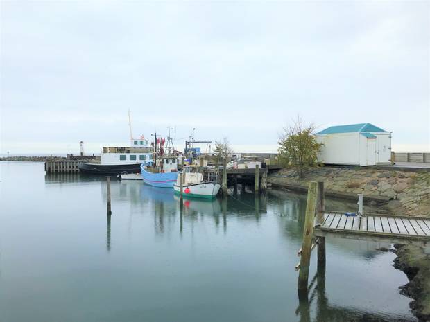 Kleiner Hafen mit Fischerboote, im Hintergrund ein kleiner Leuchtturm