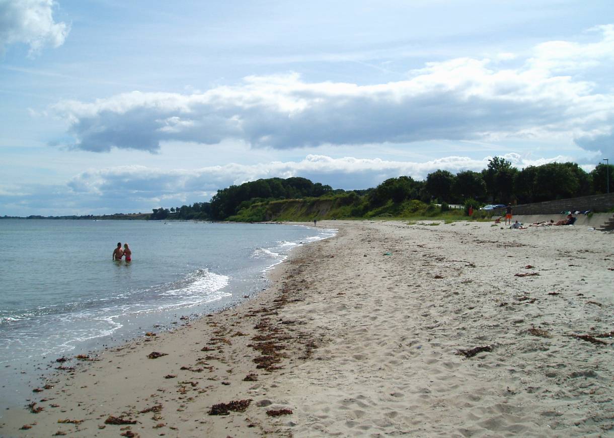 Sandstrand hinter einer kleinen Mauer
