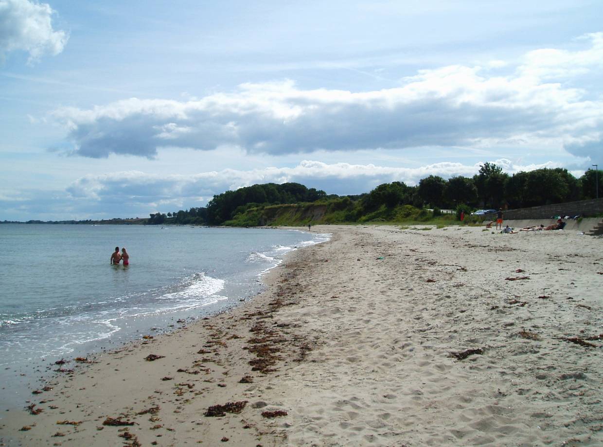 Sandstrand hinter einer kleinen Mauer
