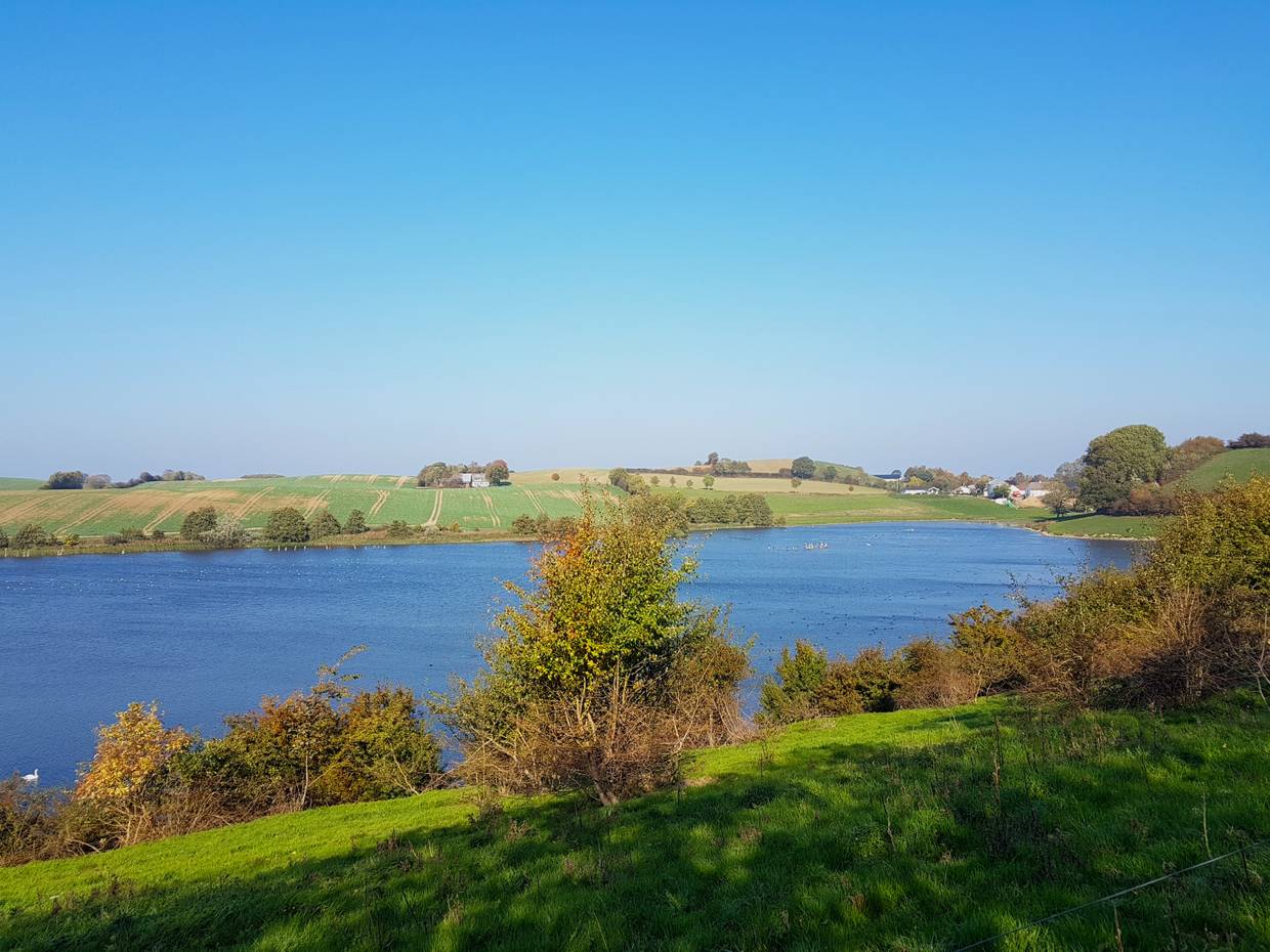 Blick auf einen See in einem grünen Tal