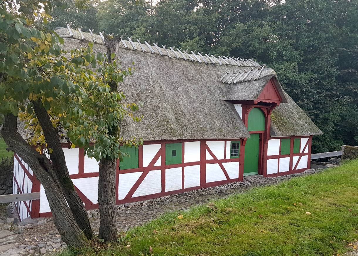 Ein kleines Fachwerkhaus mit Reetdach am Waldrand