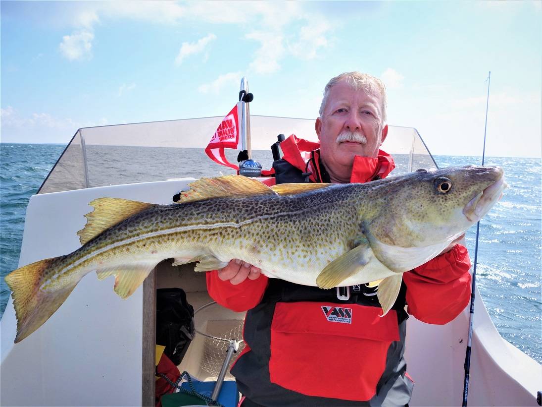 Angler präsentiert seinen Fang auf einem Mietboot