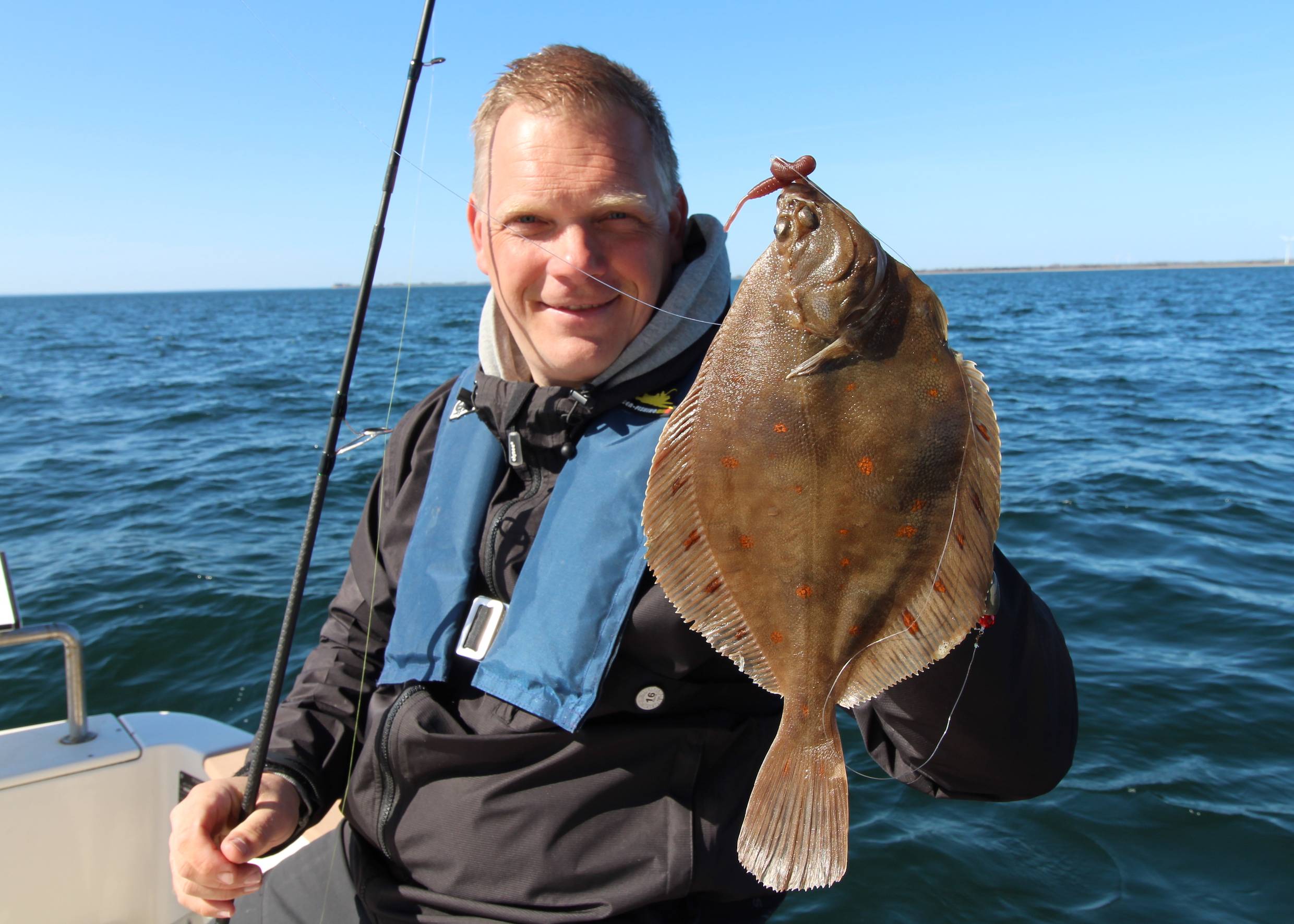Angler zeigt eine große Scholle