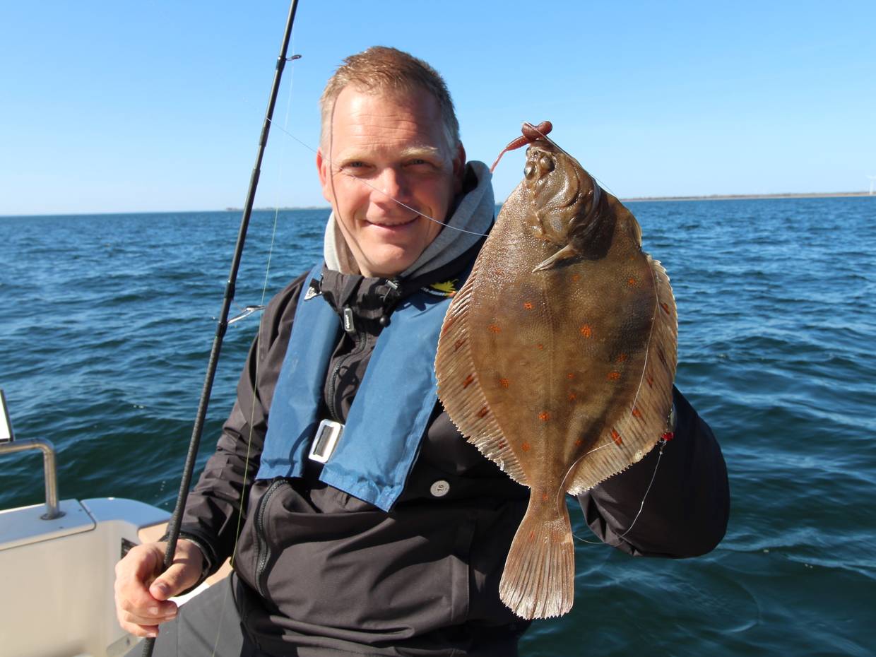 Angler zeigt eine große Scholle