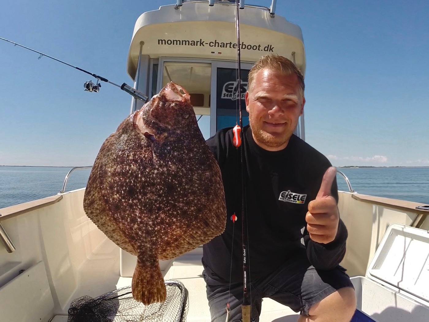 Angler mit einem Steinbutt 