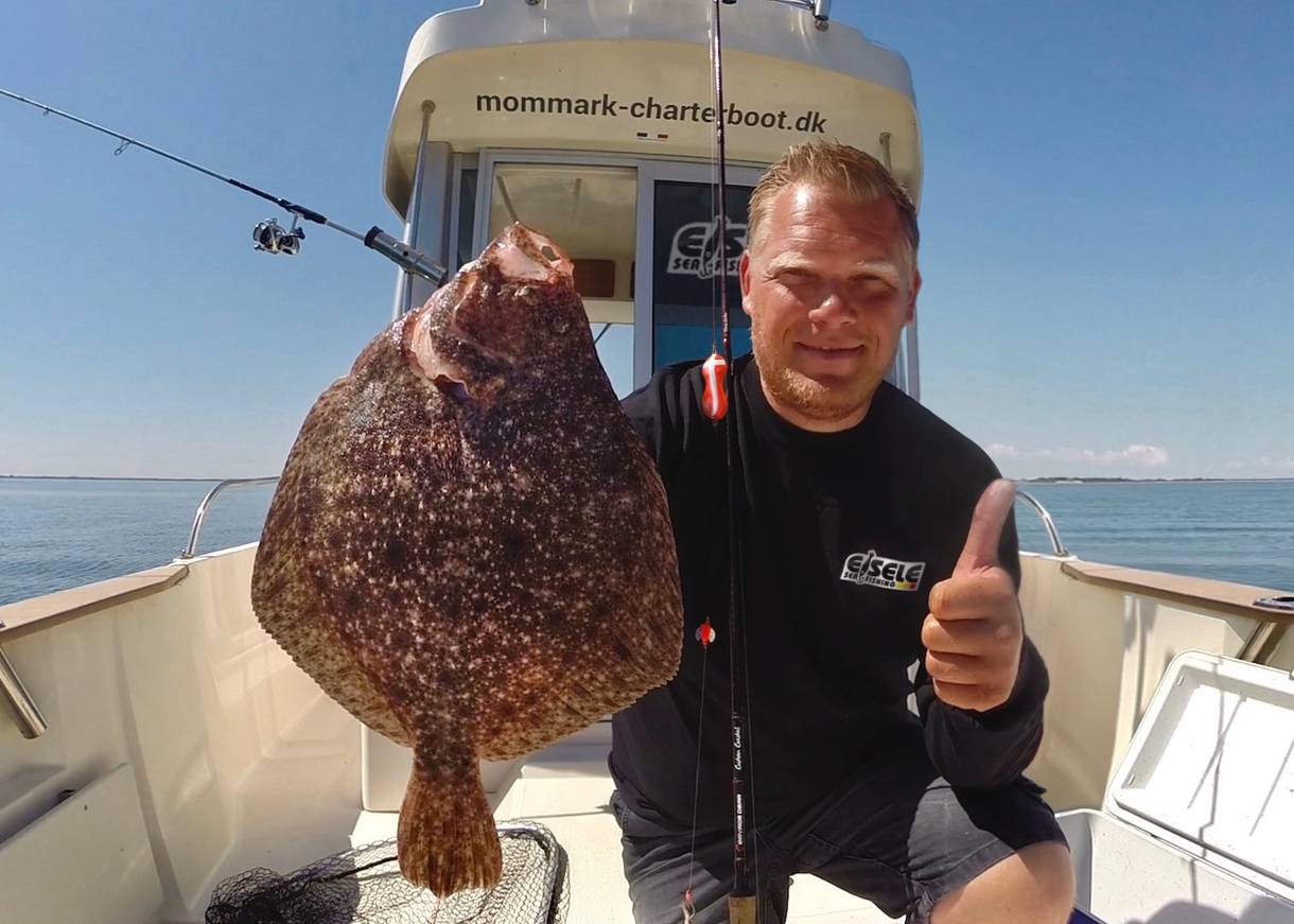 Angler mit einem Steinbutt 