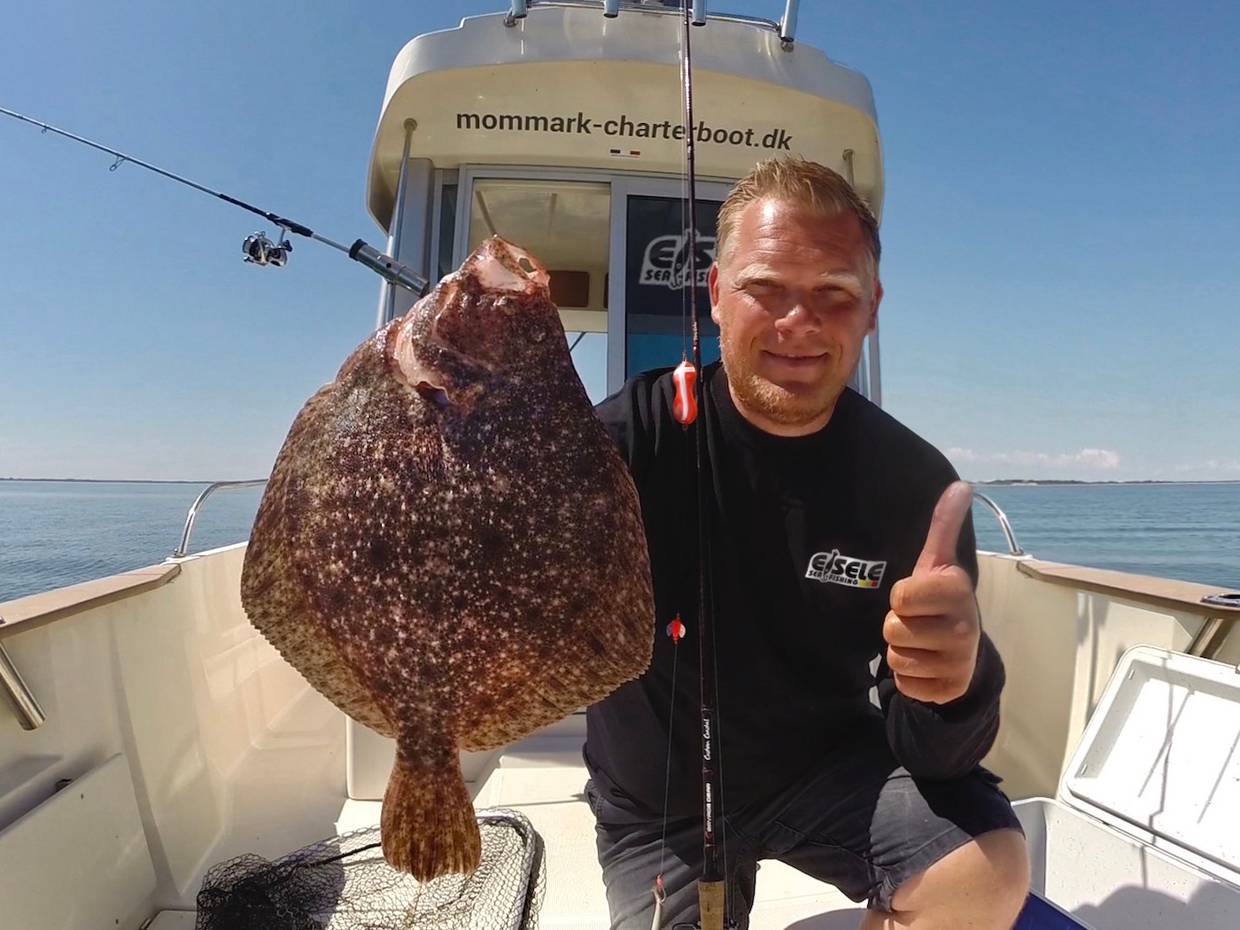 Angler mit einem Steinbutt 