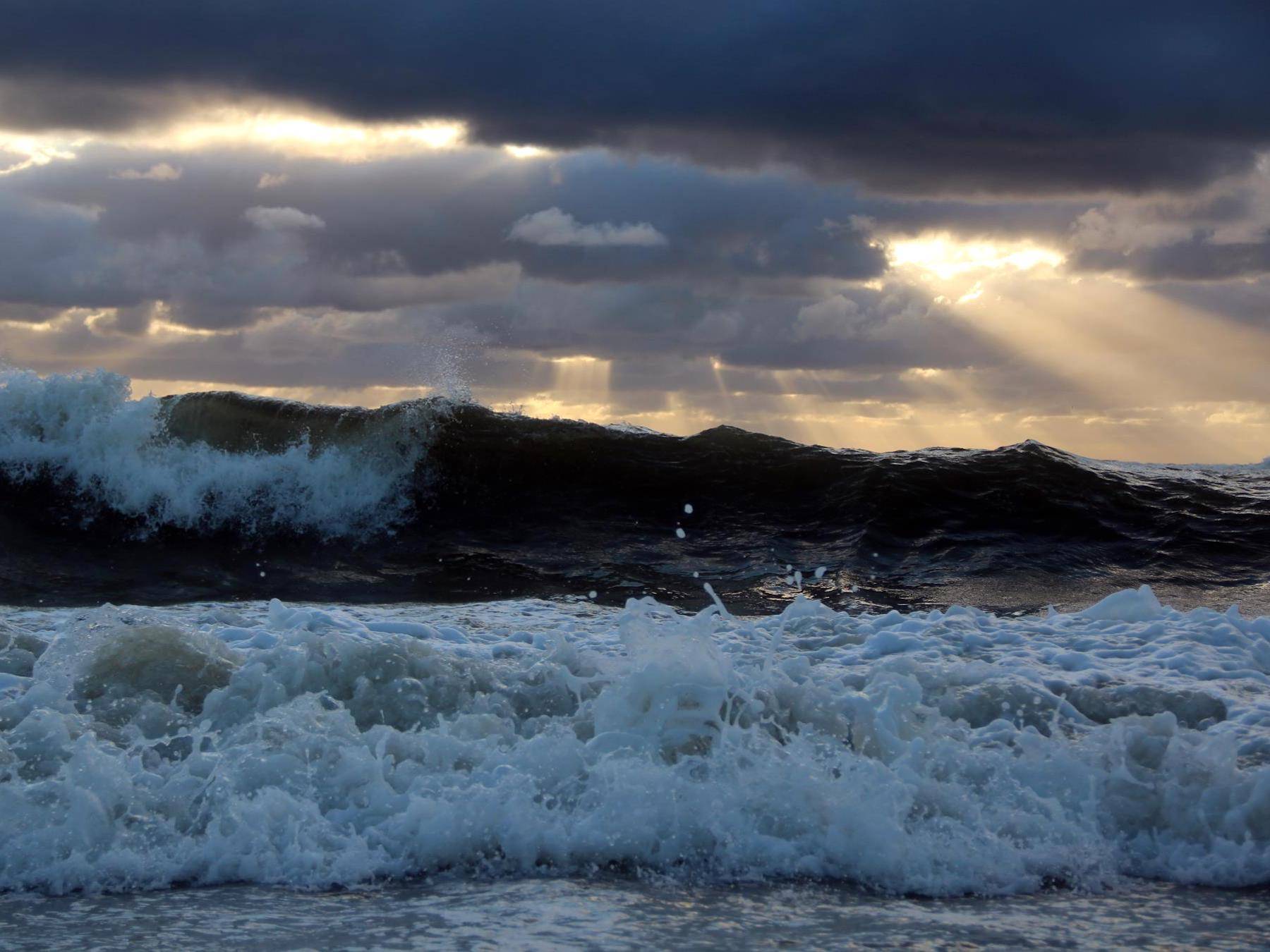 Hohe Wellen und dunkle Wolken über dem Meer