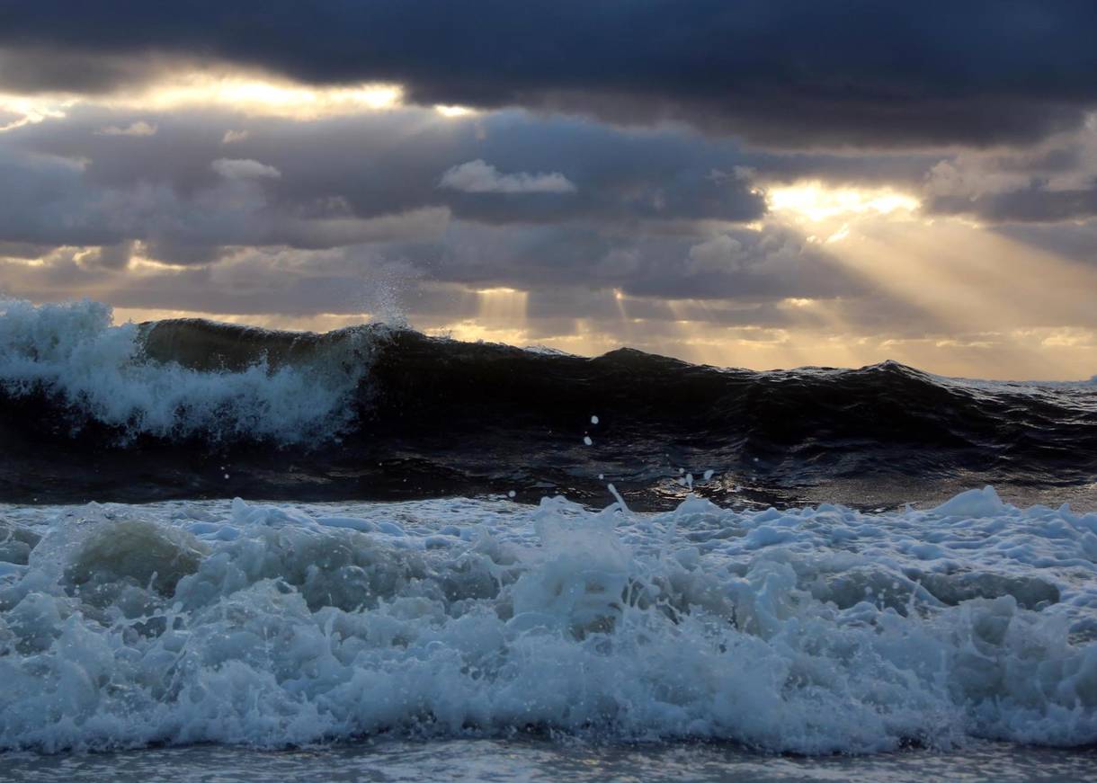 Hohe Wellen und dunkle Wolken über dem Meer