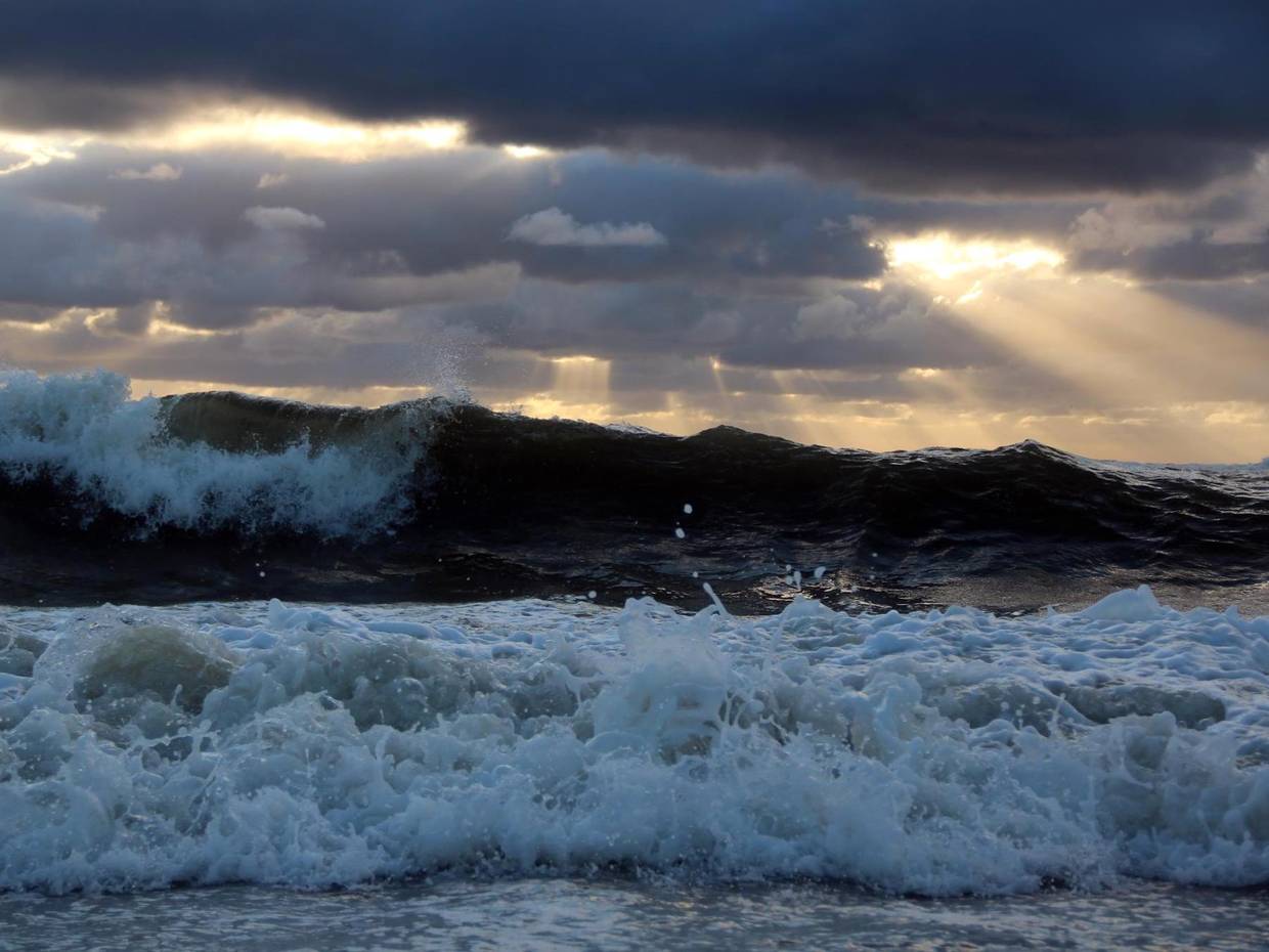 Hohe Wellen und dunkle Wolken über dem Meer