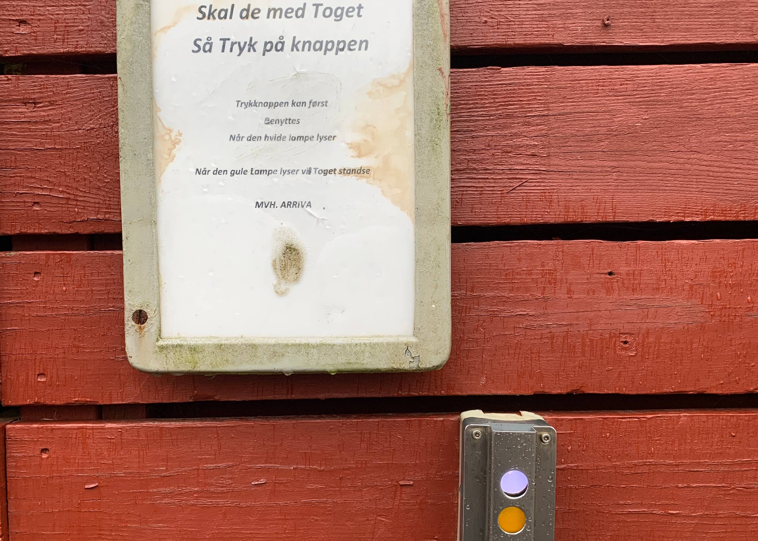 Infotafel auf einer Holzwand und eine elektrische Einrichtung mit drei Knöpfen