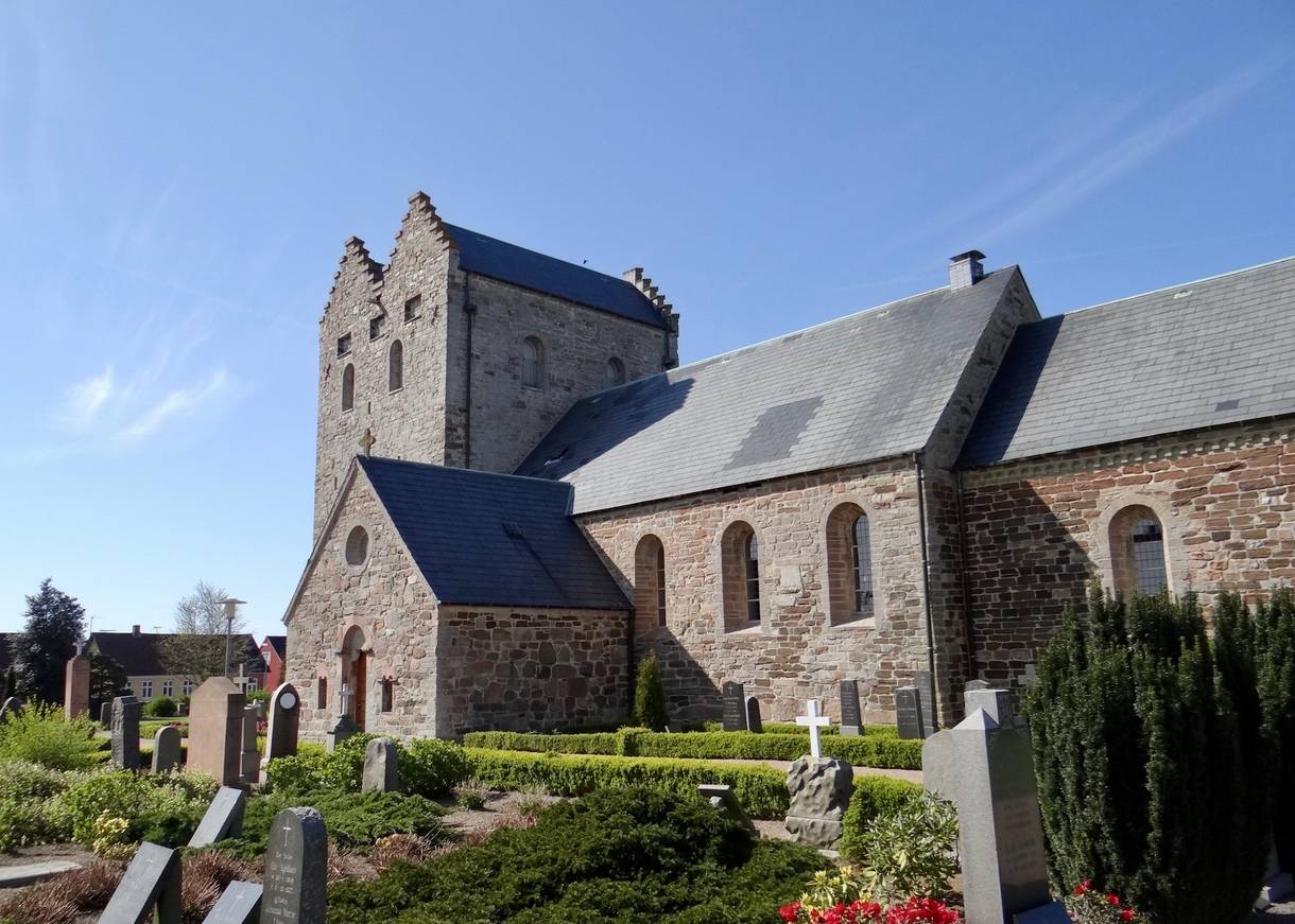 Große graue Kirche, davor ein Friedhof