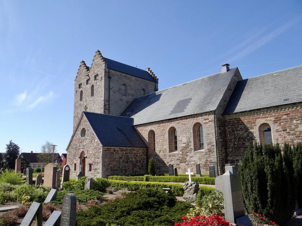 Große graue Kirche, davor ein Friedhof