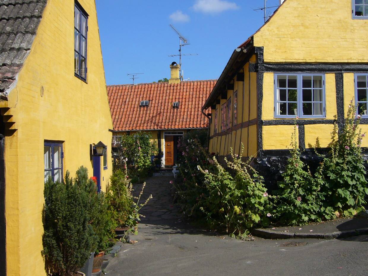 Schmale Gassen mit gelben Fachwerkhäusernund üppigen Blumen vor den Häusern