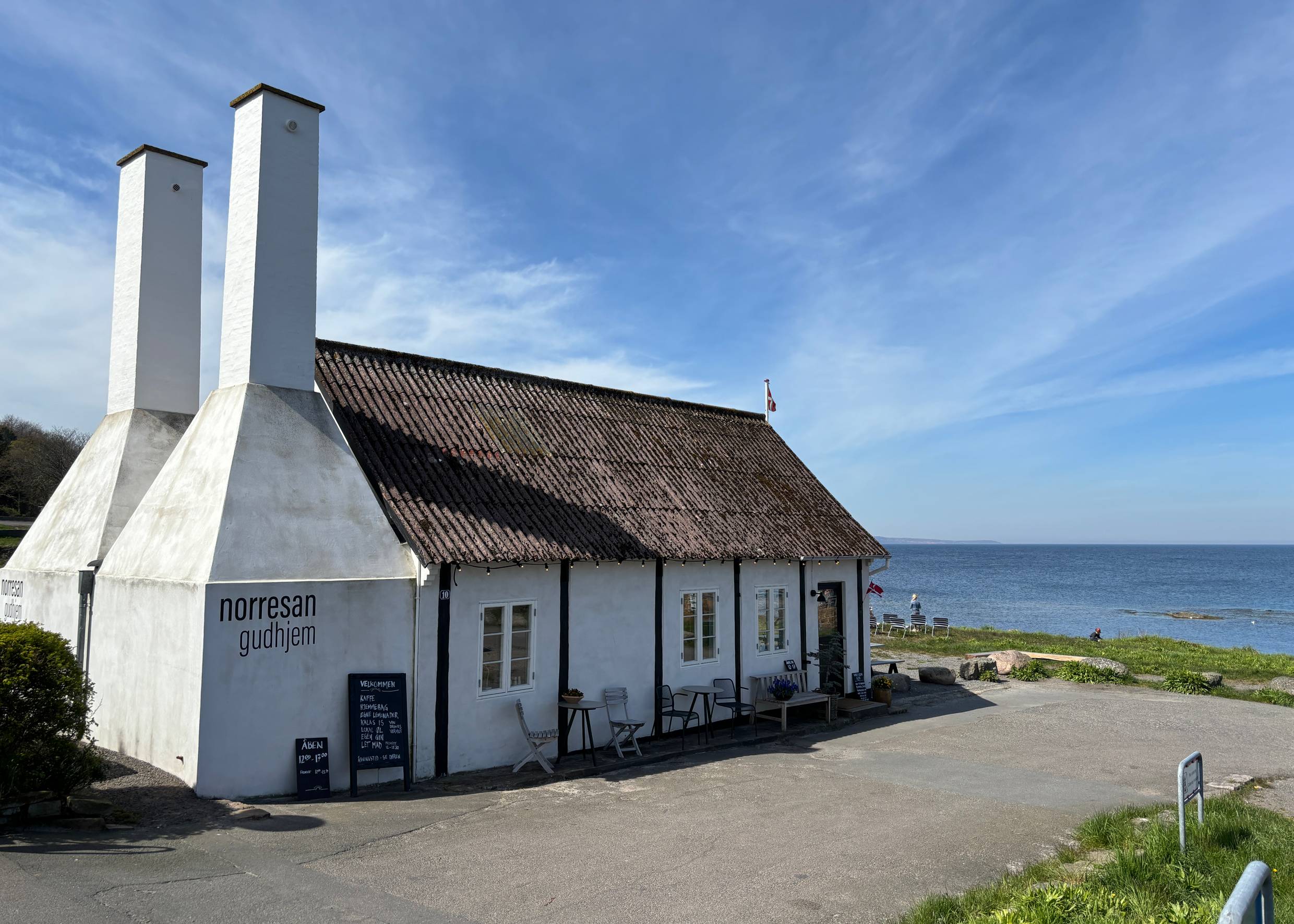 Alte, restaurierte Räucherei mit Sitzgelegenheiten und Blick auf das Meer