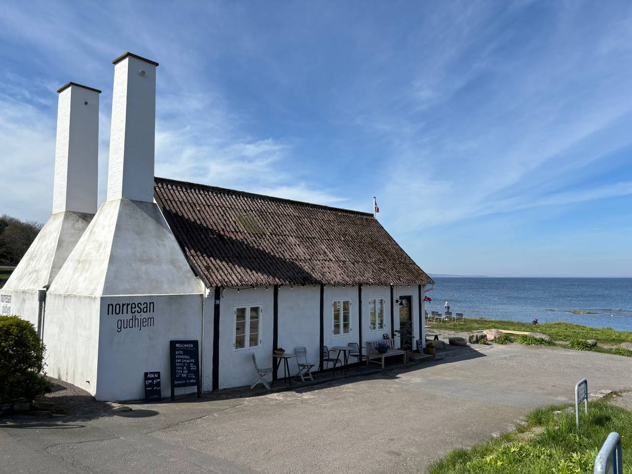 Alte, restaurierte Räucherei mit Sitzgelegenheiten und Blick auf das Meer