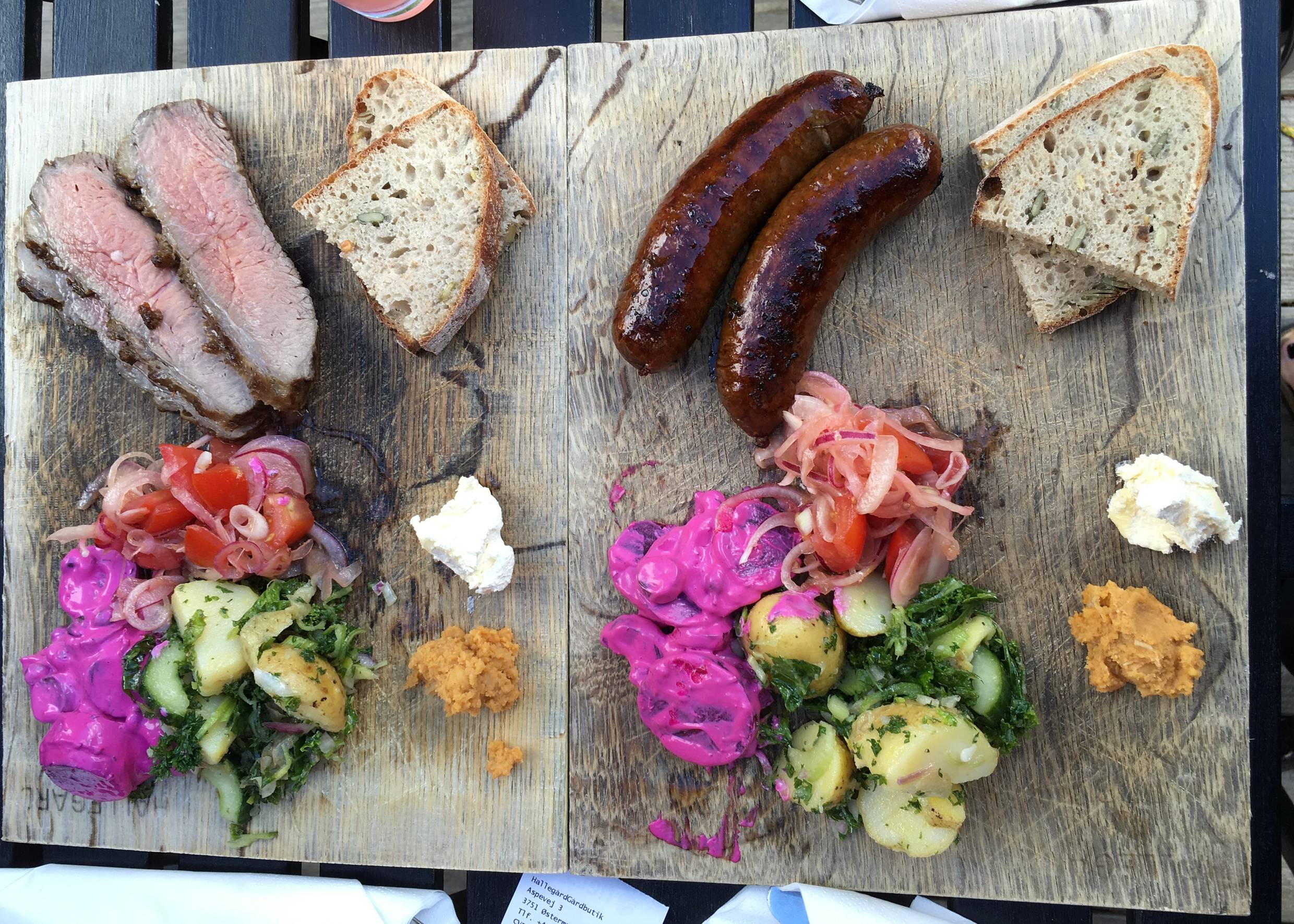 Zwei Holzbretter mit Grillwürste und Salat