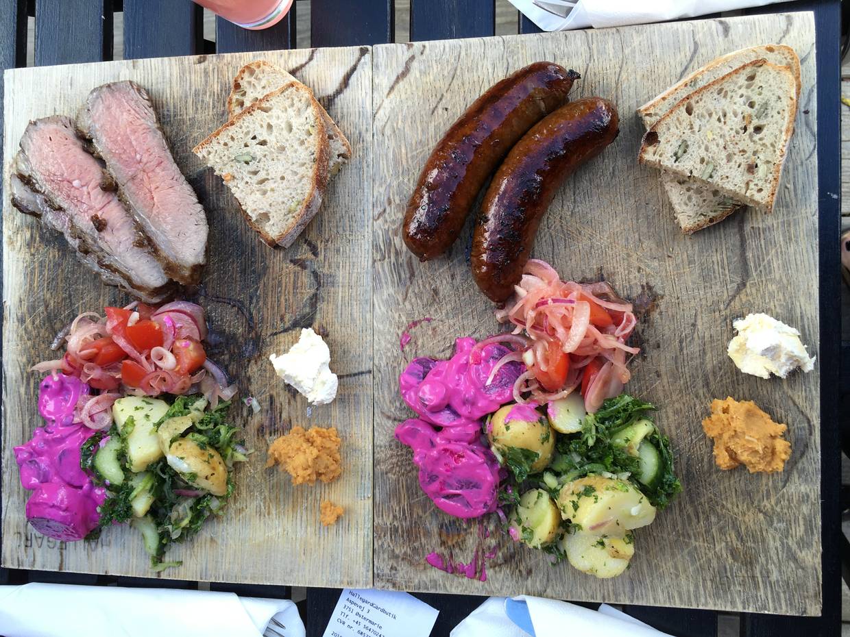 Zwei Holzbretter mit Grillwürste und Salat