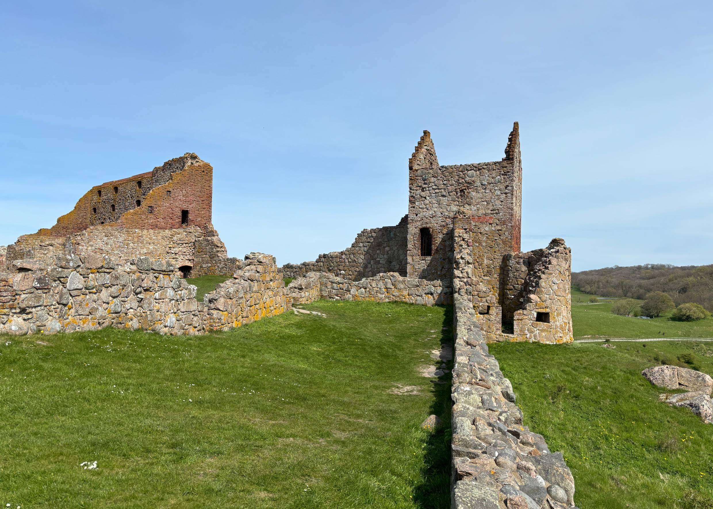 Blick auf eine Burgruine unter blauem Himmel 