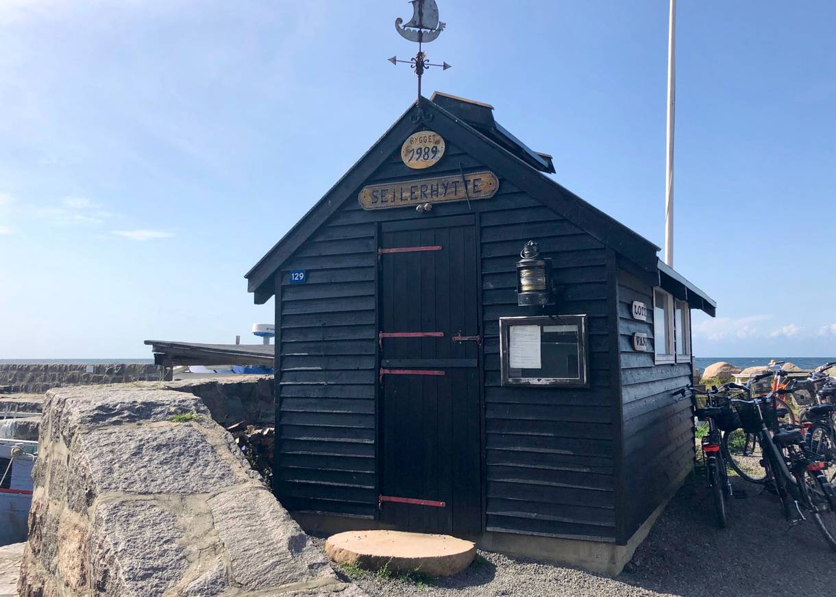Kleine alte Holzhütte am Hafen, daneben Fahrräder