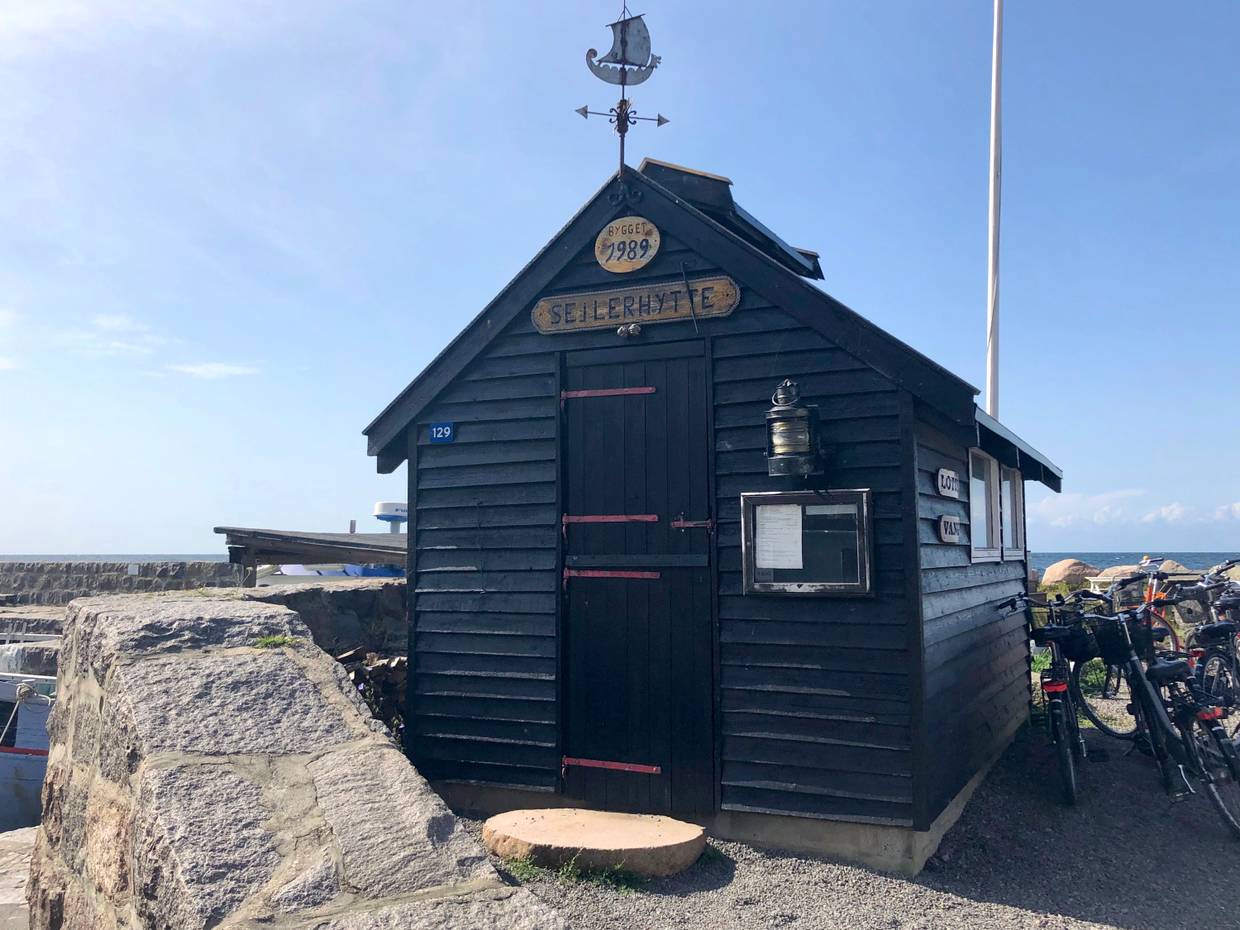 Kleine alte Holzhütte am Hafen, daneben Fahrräder