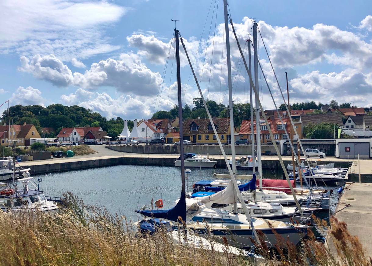 Hafenbecken mit einigen Segelbooten, im Hintergrund Fischerhäuser